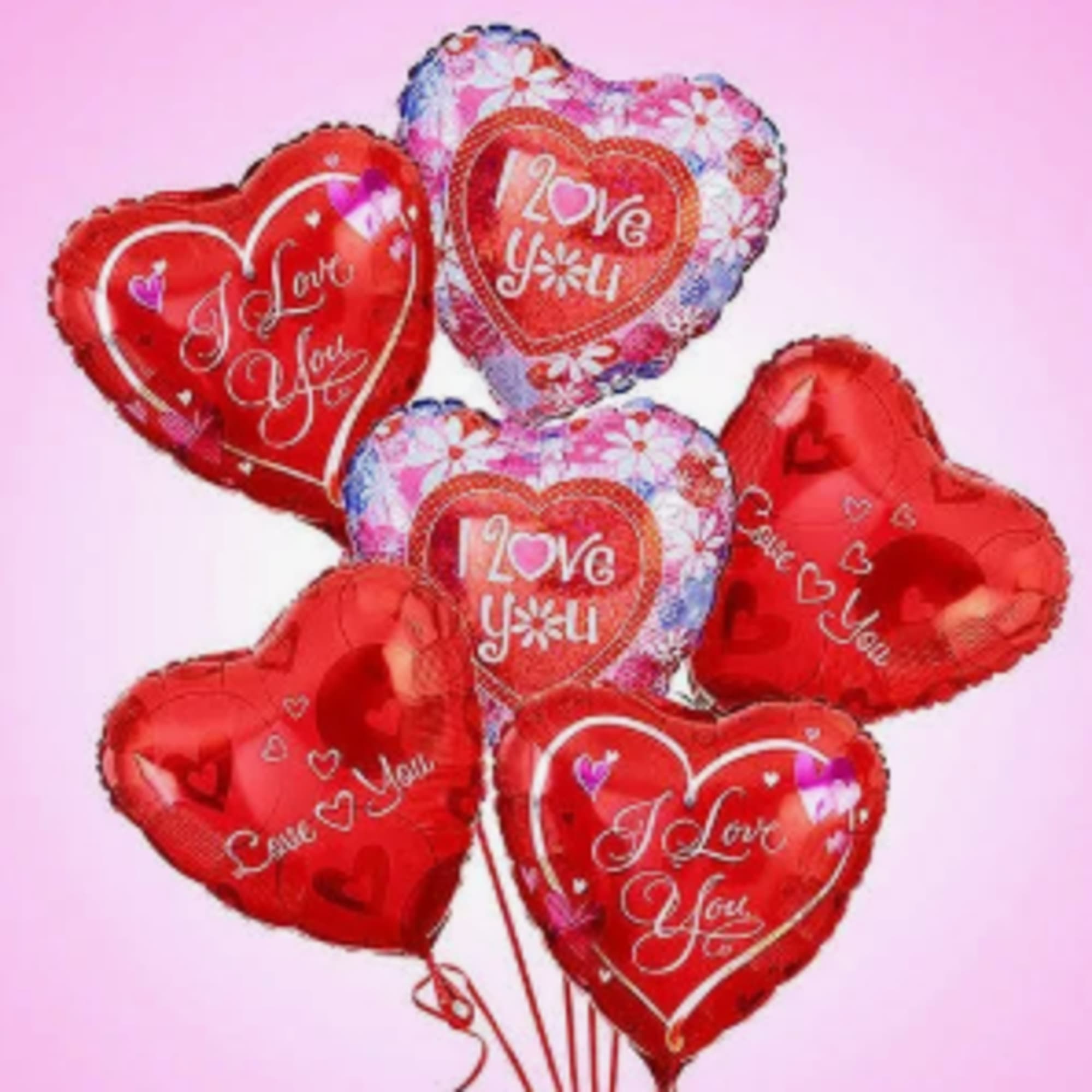 Cluster of heart-shaped red and floral balloons with love messages
