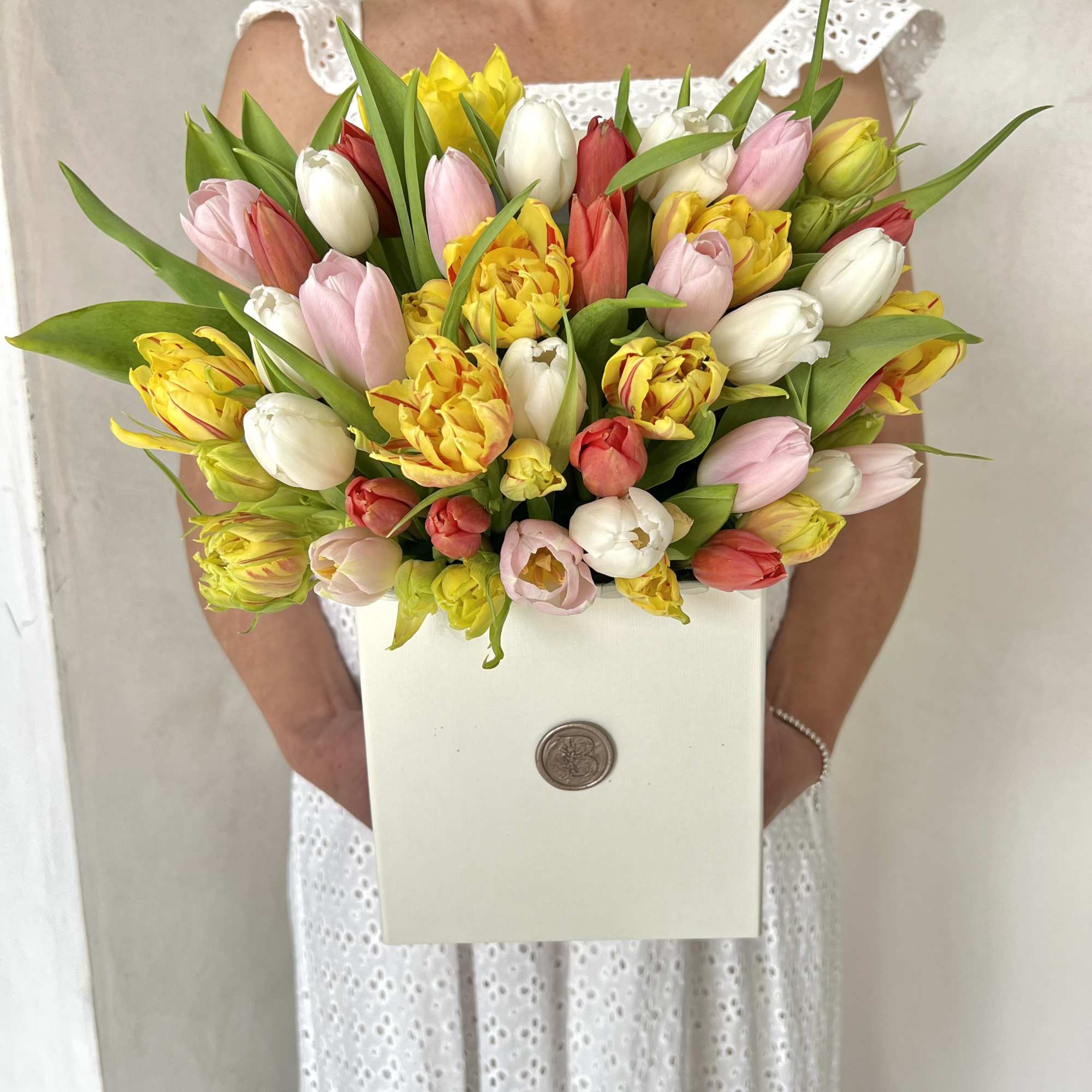Bouquet of multicolored tulips in a white box