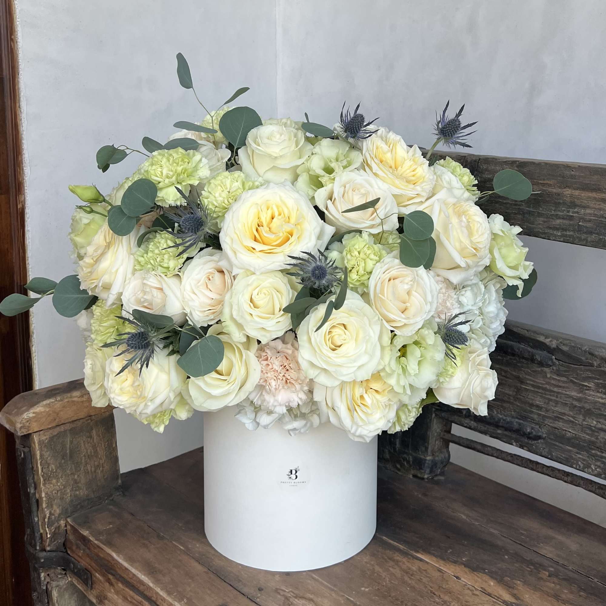 Cream and pale yellow rose bouquet in a white hatbox