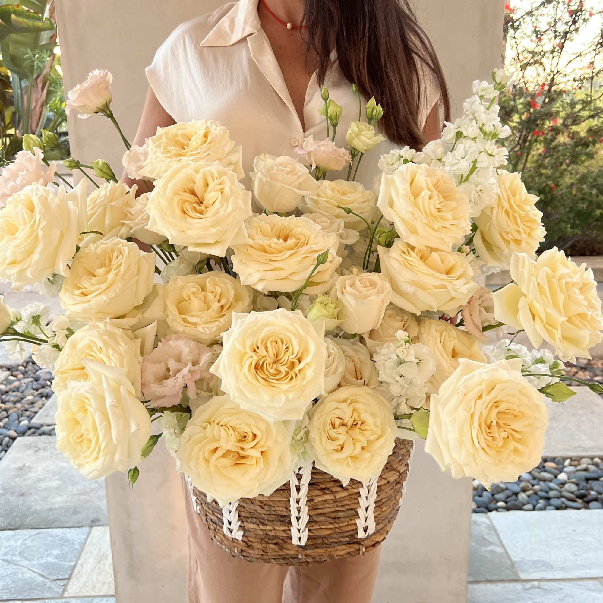 Large basket arrangement of pale yellow roses and white blooms