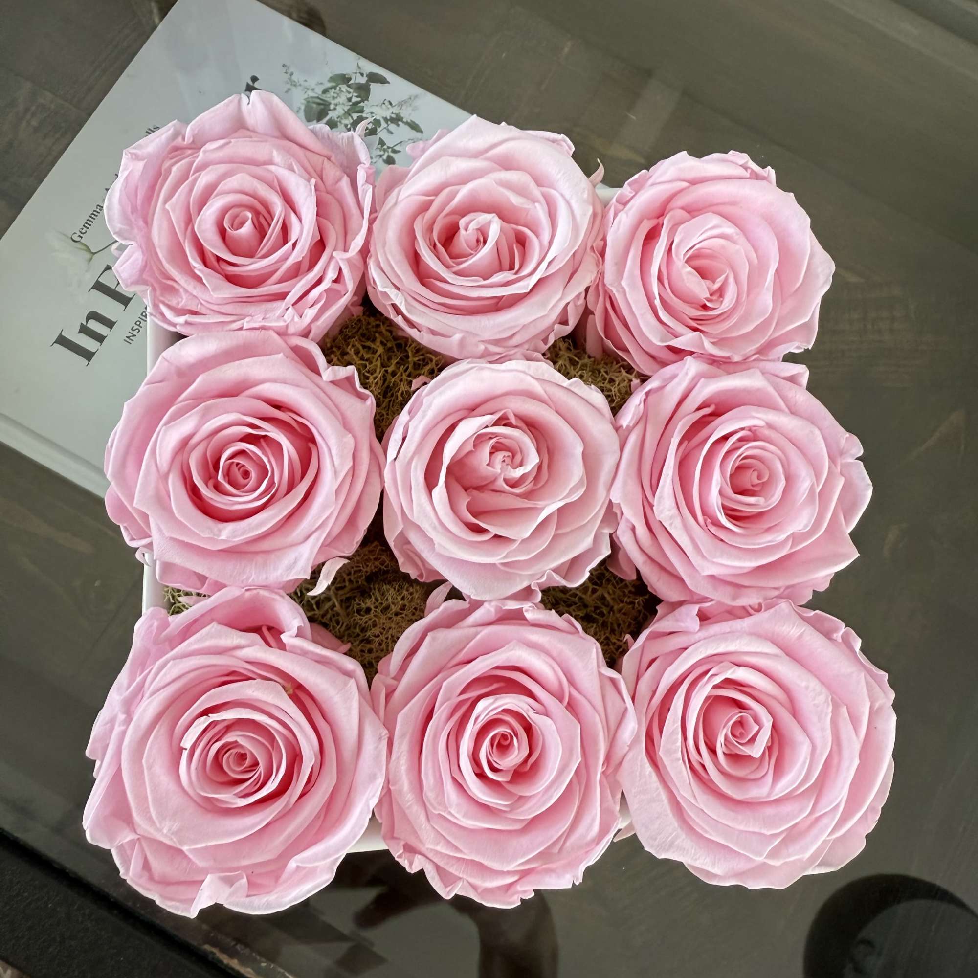 Nine pink roses arranged in a square box