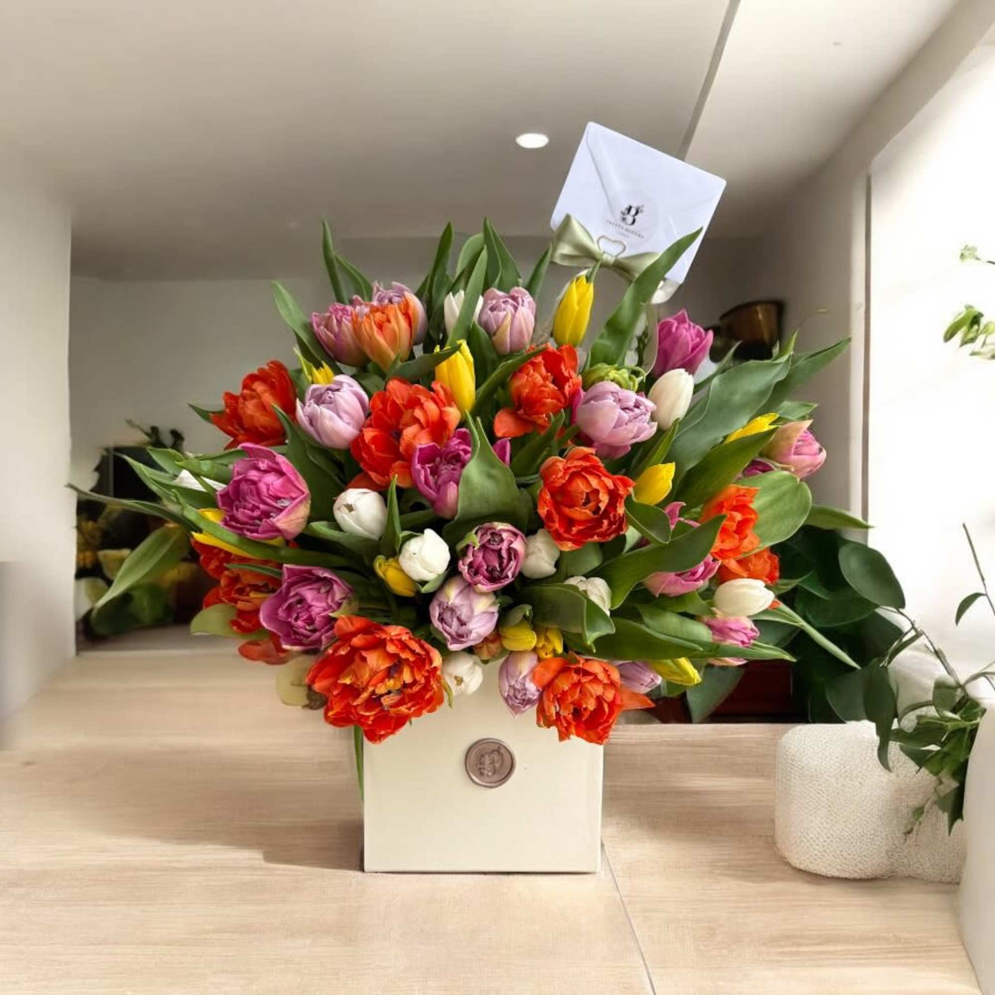 Colorful tulip bouquet in a white box with a ribbon
