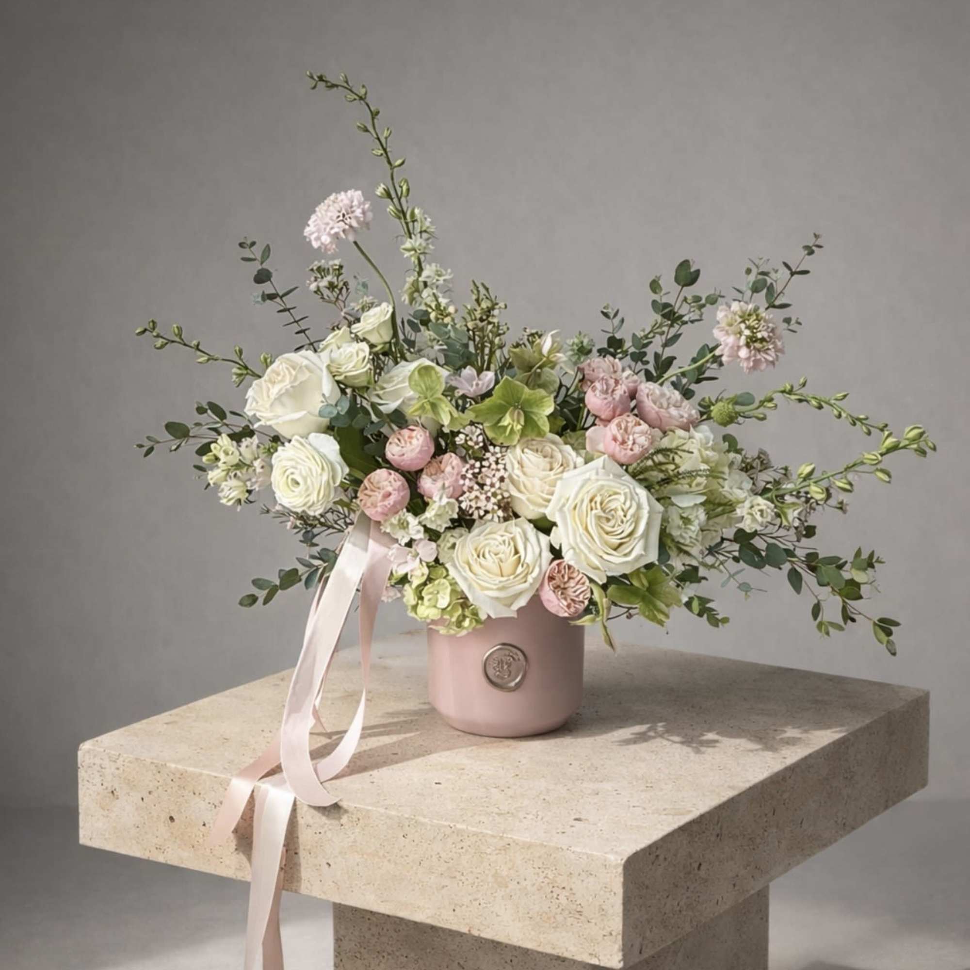 Pink and white rose bouquet in a blush vase with ribbon