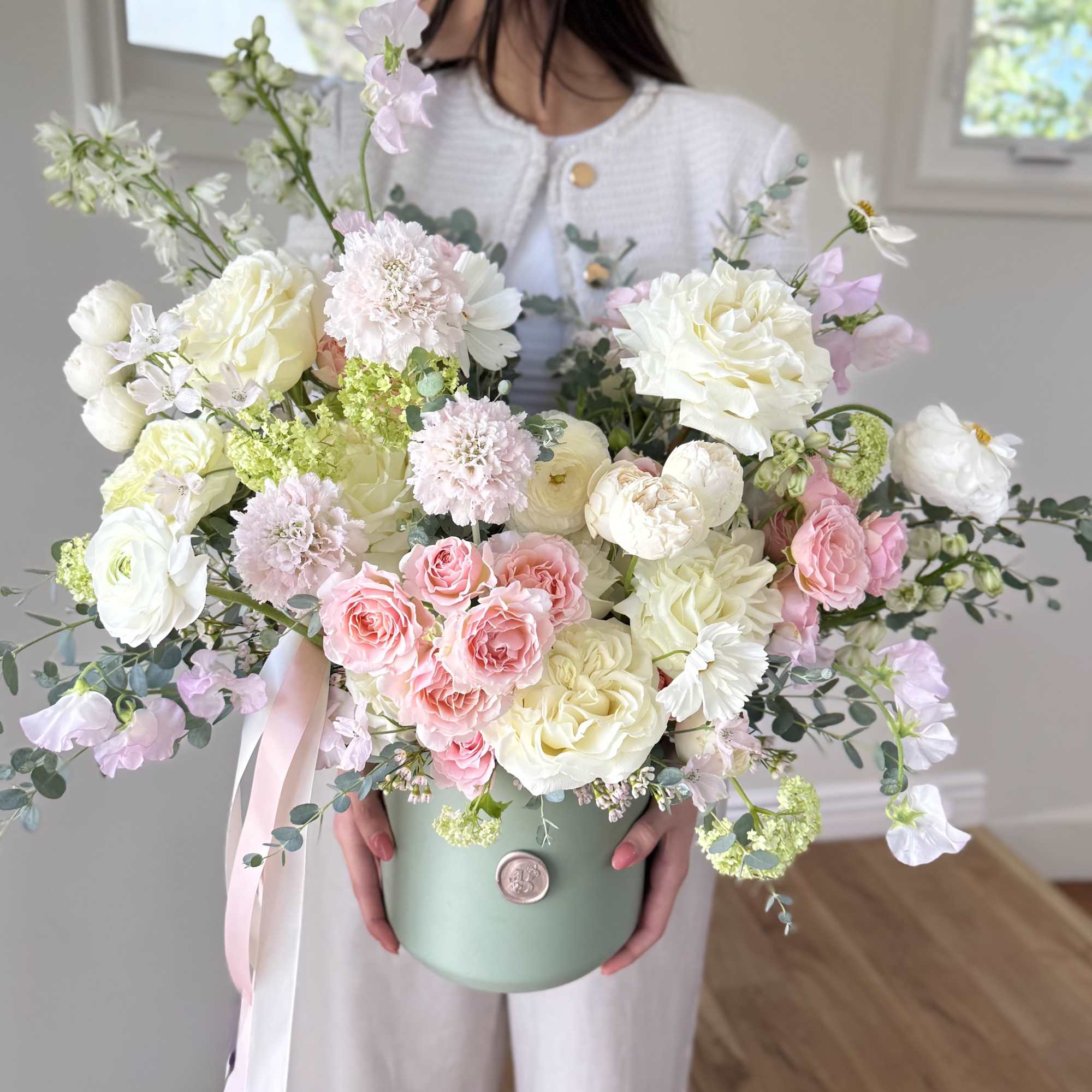A soft and refreshing arrangement of seasonal blooms in blush and cream