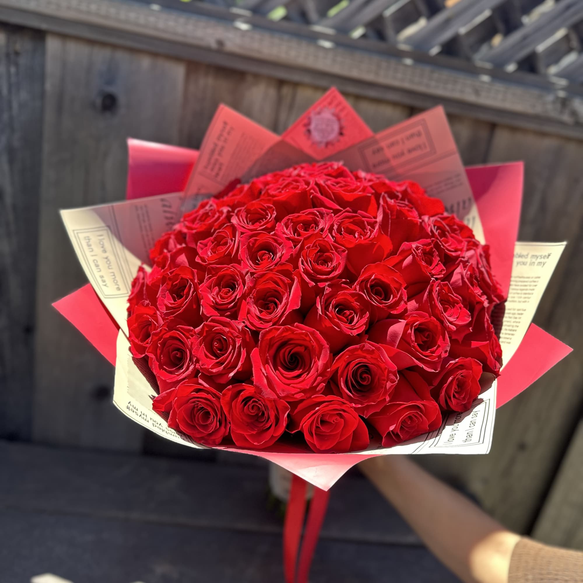 Bouquet of red roses wrapped in pink and cream paper