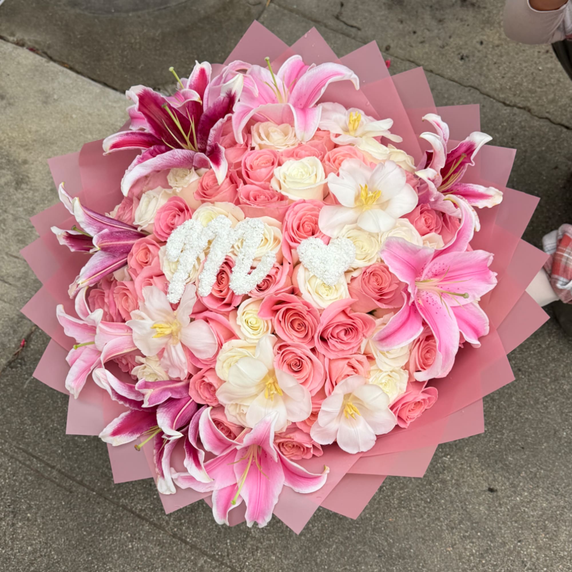 Pink and white rose bouquet with lilies wrapped in pink paper