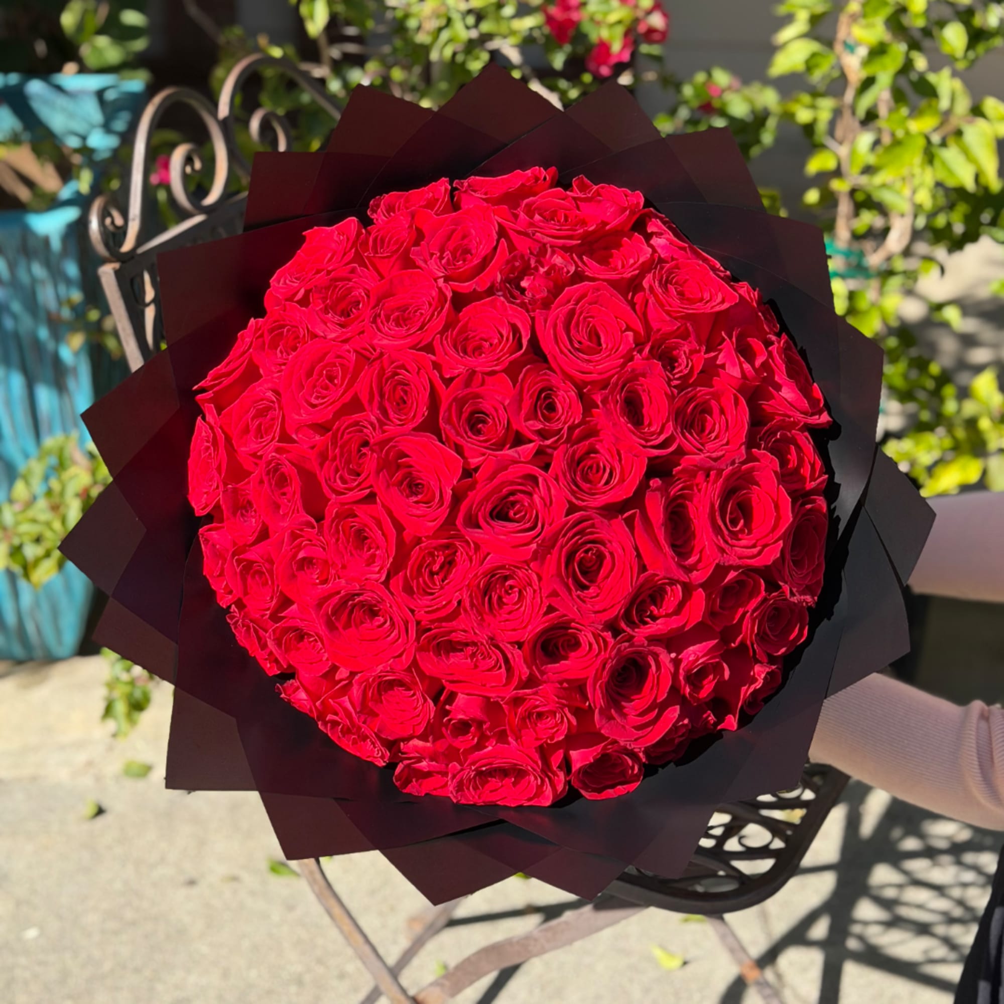 Large bouquet of red roses wrapped in black paper