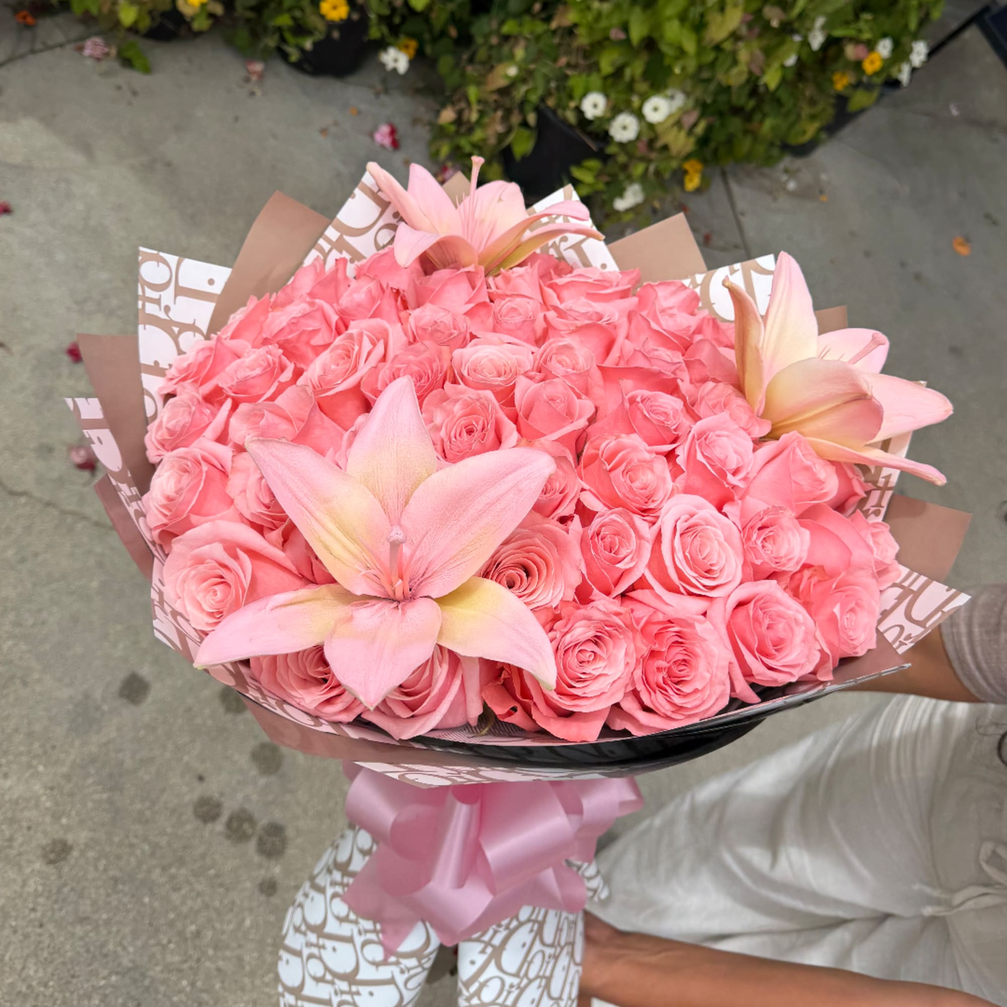Pink rose bouquet with three pale pink lilies wrapped in patterned paper