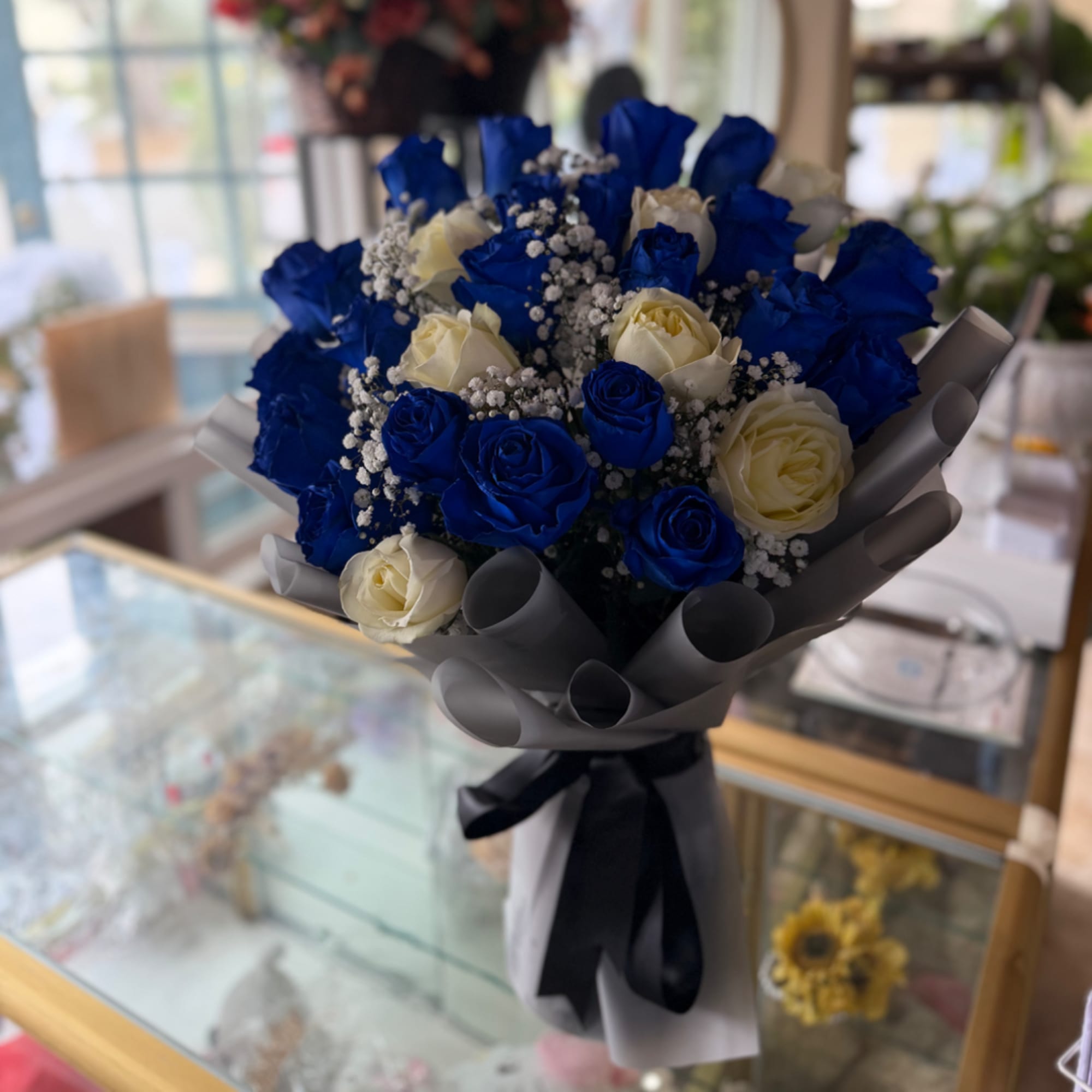 Bouquet of blue and white roses wrapped in gray paper, photo 2 of 3