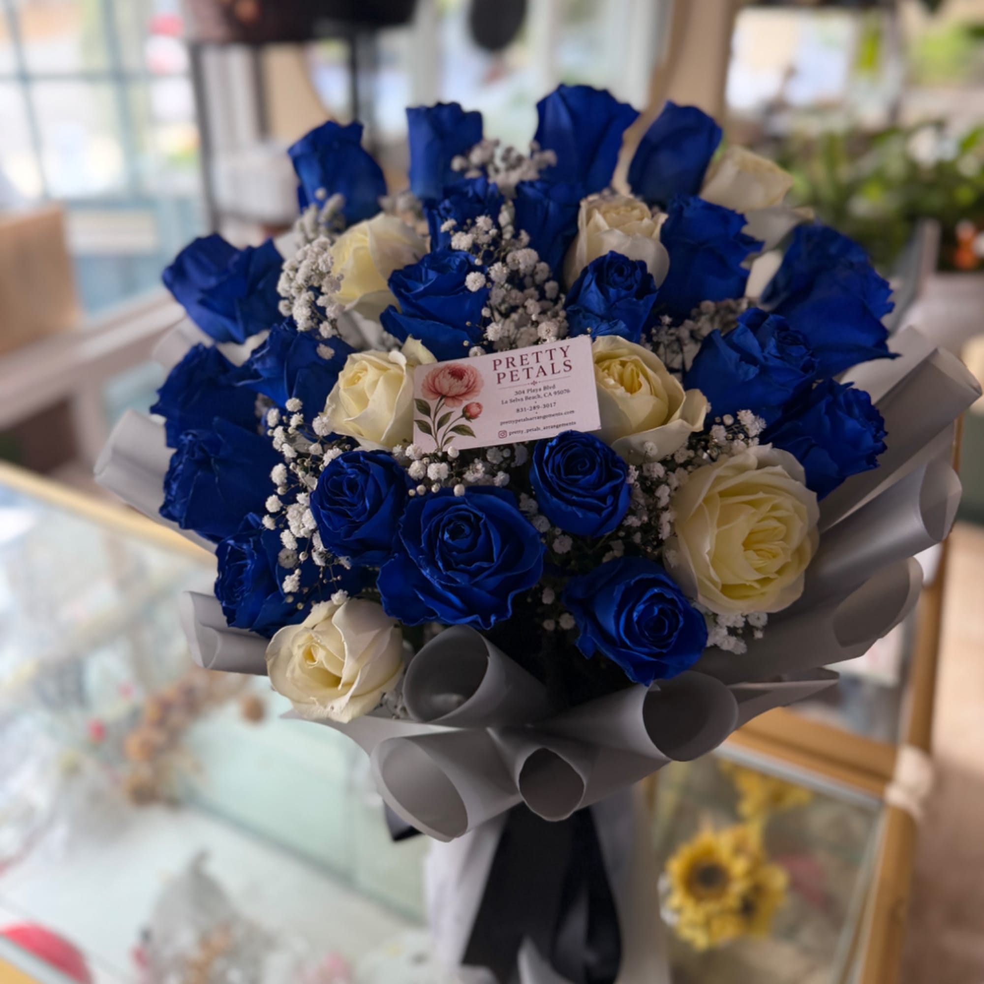Bouquet of blue and cream roses wrapped in gray paper