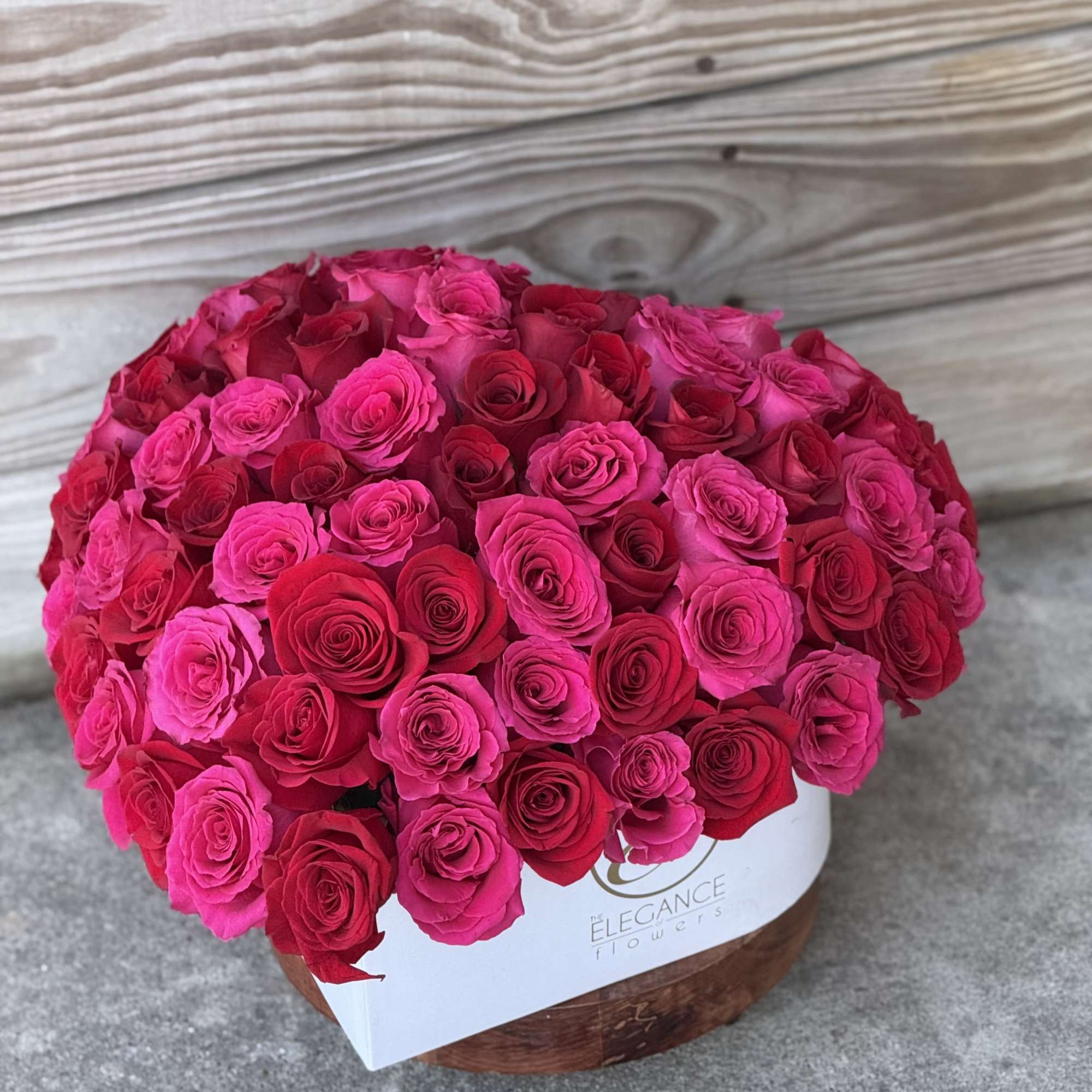Large round bouquet of pink and red roses in a white box