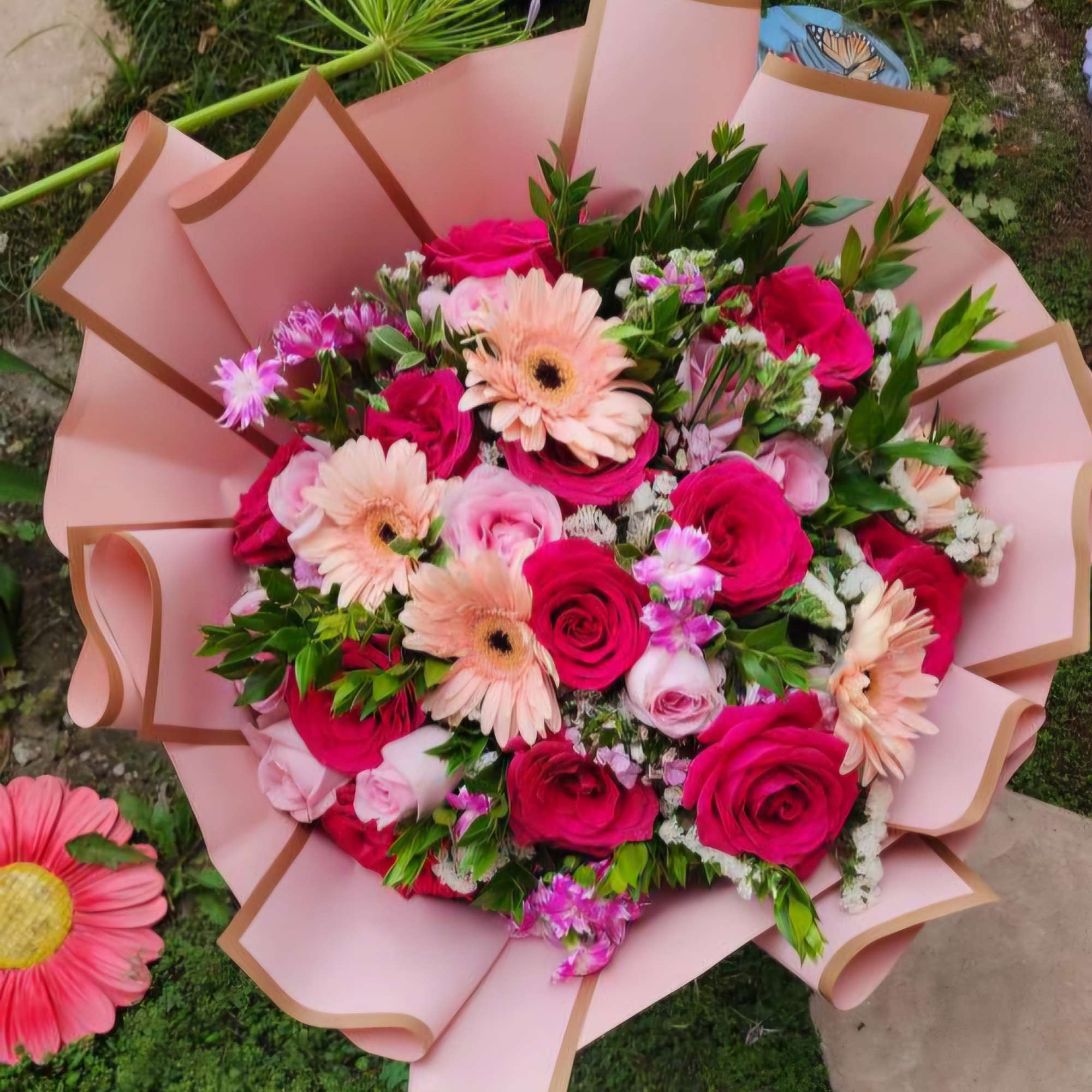 This wrap bouquet shown in large.
2 dozen roses designer's choice. All florals