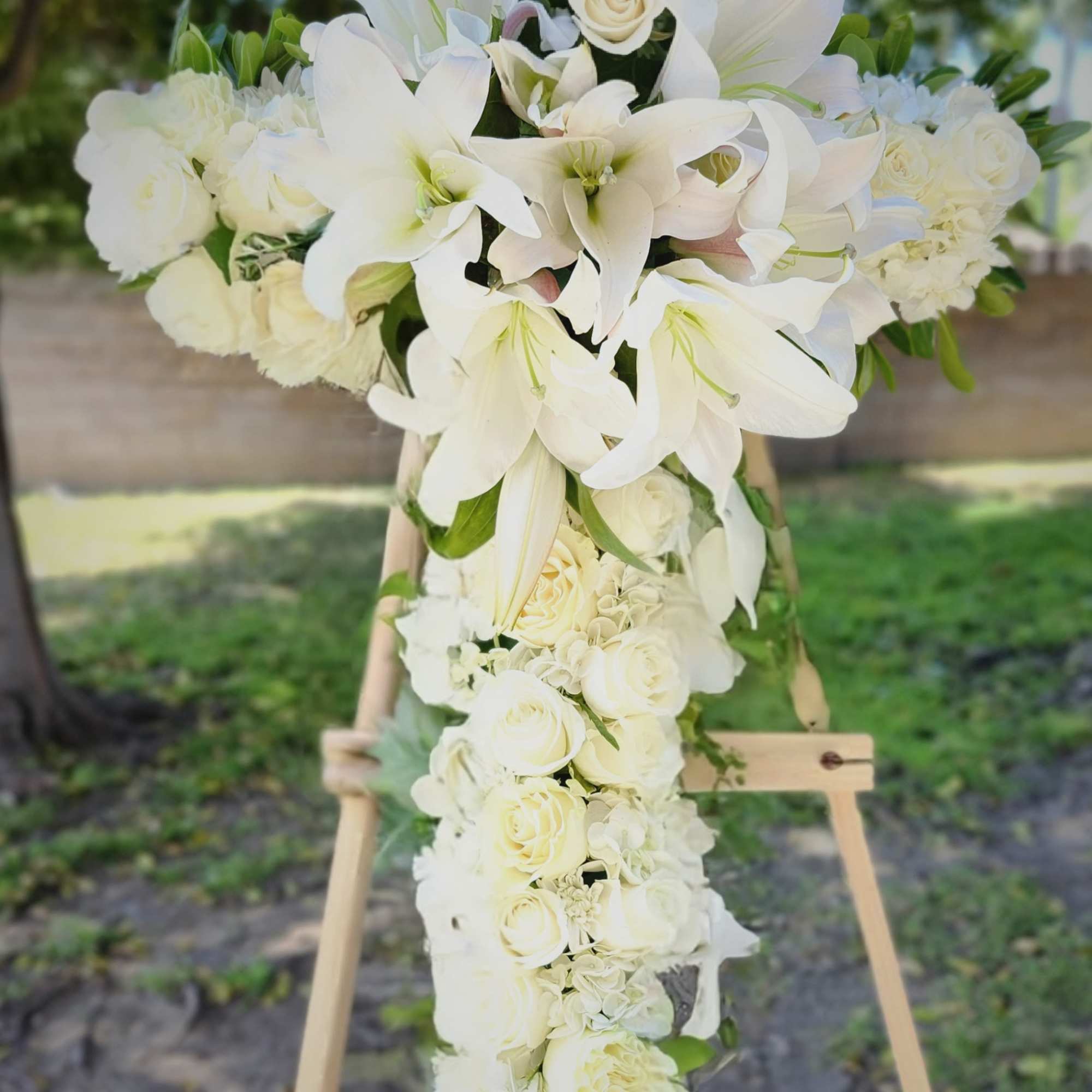 An all white tribute, this white cross funeral spray is pure and