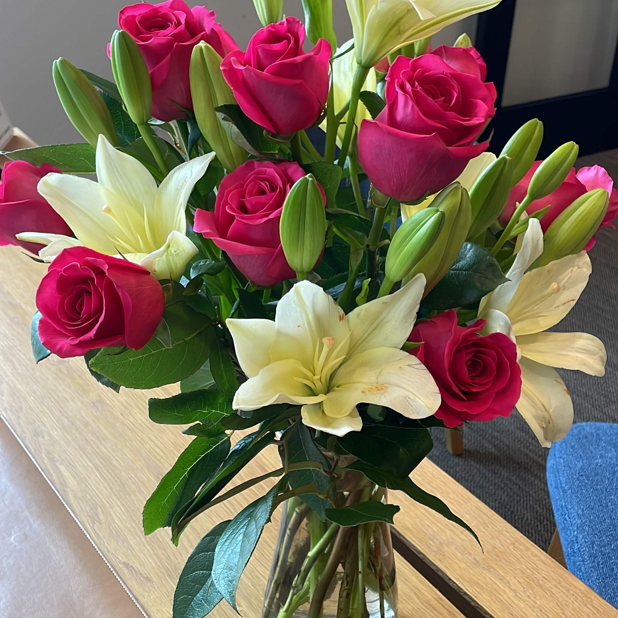 Pink roses and white lilies arranged in a clear glass vase