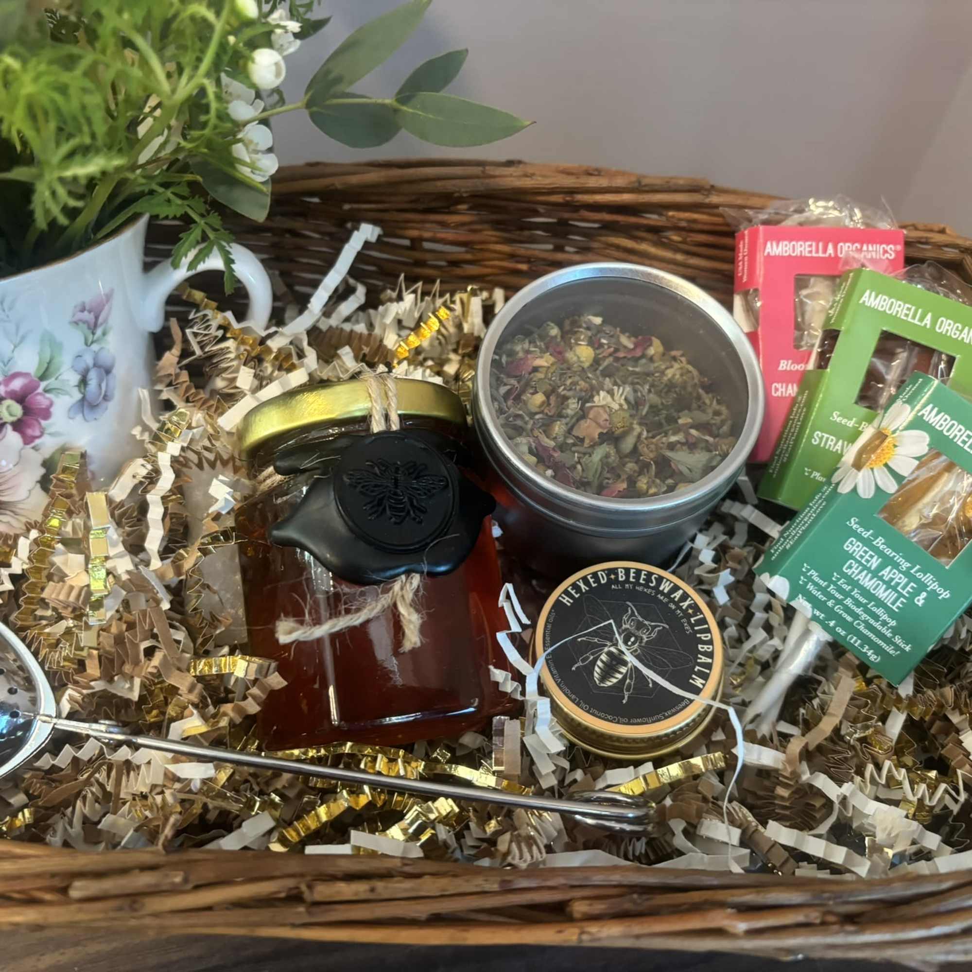 A basket filled with flowers, tea, and treats.  The flower arrangement, photo 2 of 3
