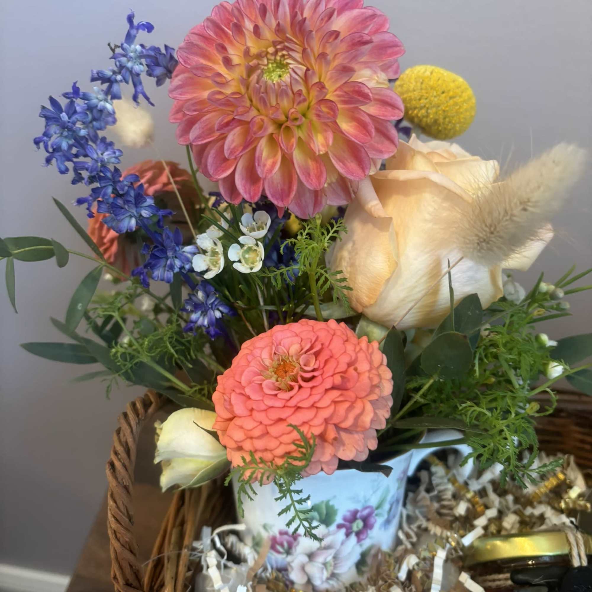 A basket filled with flowers, tea, and treats.  The flower arrangement, photo 3 of 3