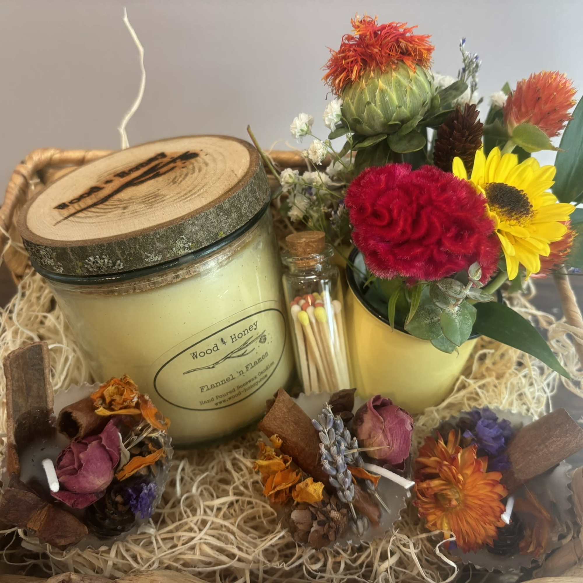 Gift basket with a candle, matches, and a small flower arrangement
