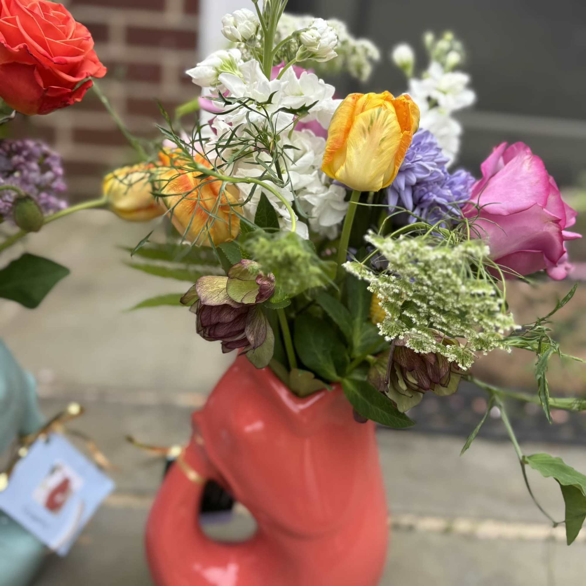 A colorful Gurgle Pot bursting with whimsical fresh local blooms.  The