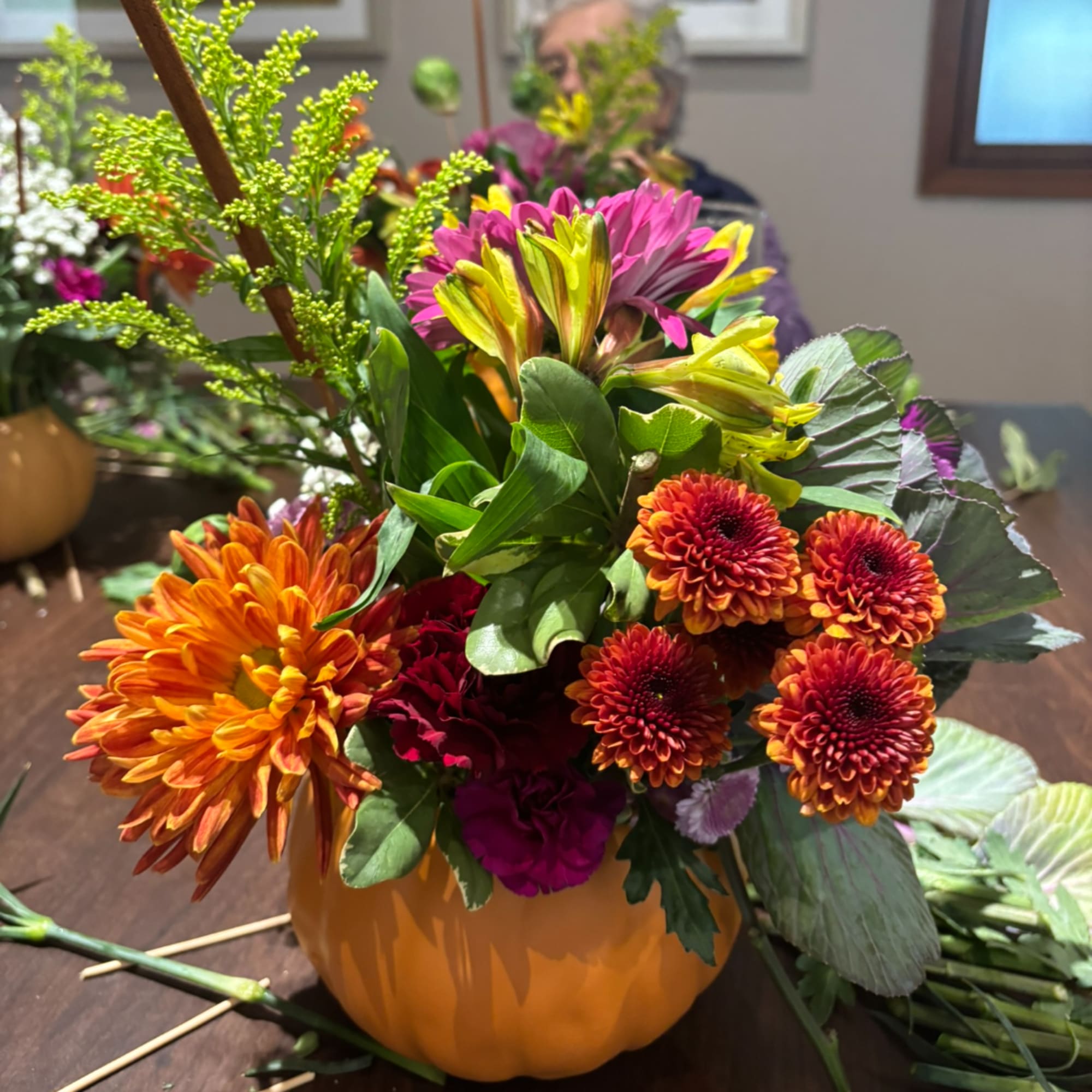 Colorful mixed flower arrangement in an orange pumpkin-shaped container