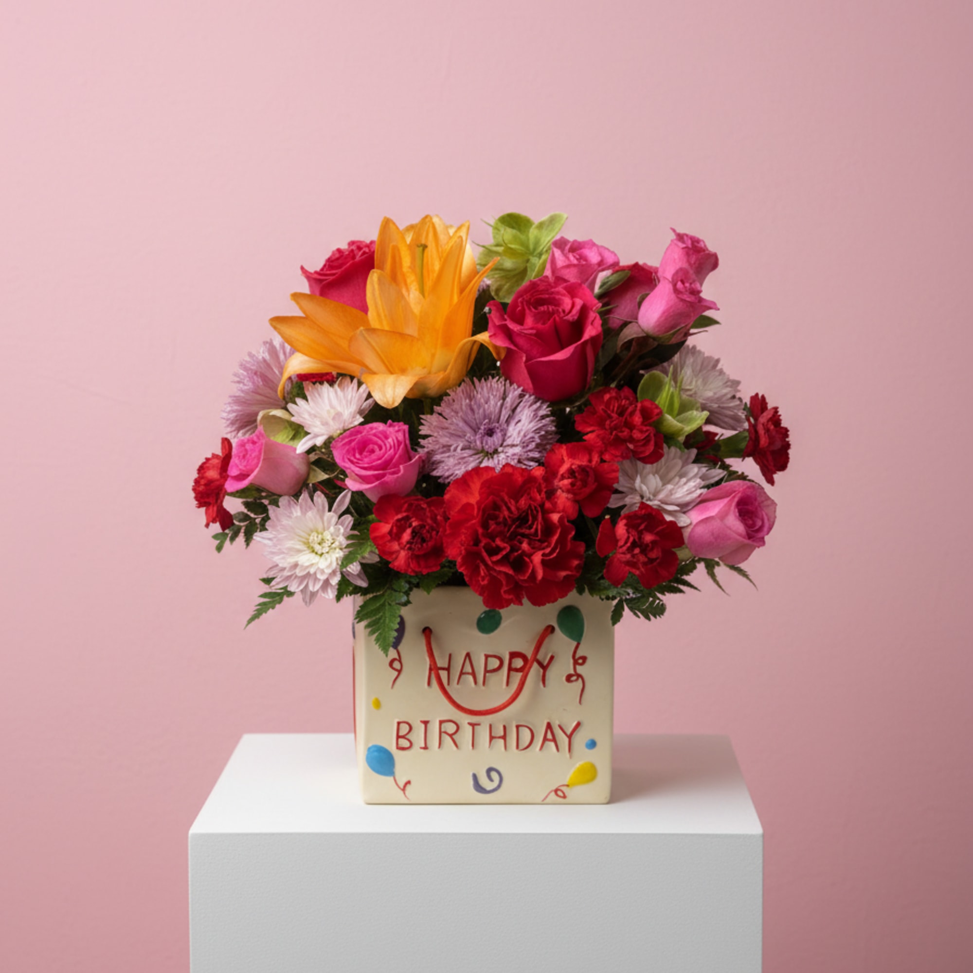 Mixed bouquet in a birthday box with pink, red, and orange flowers