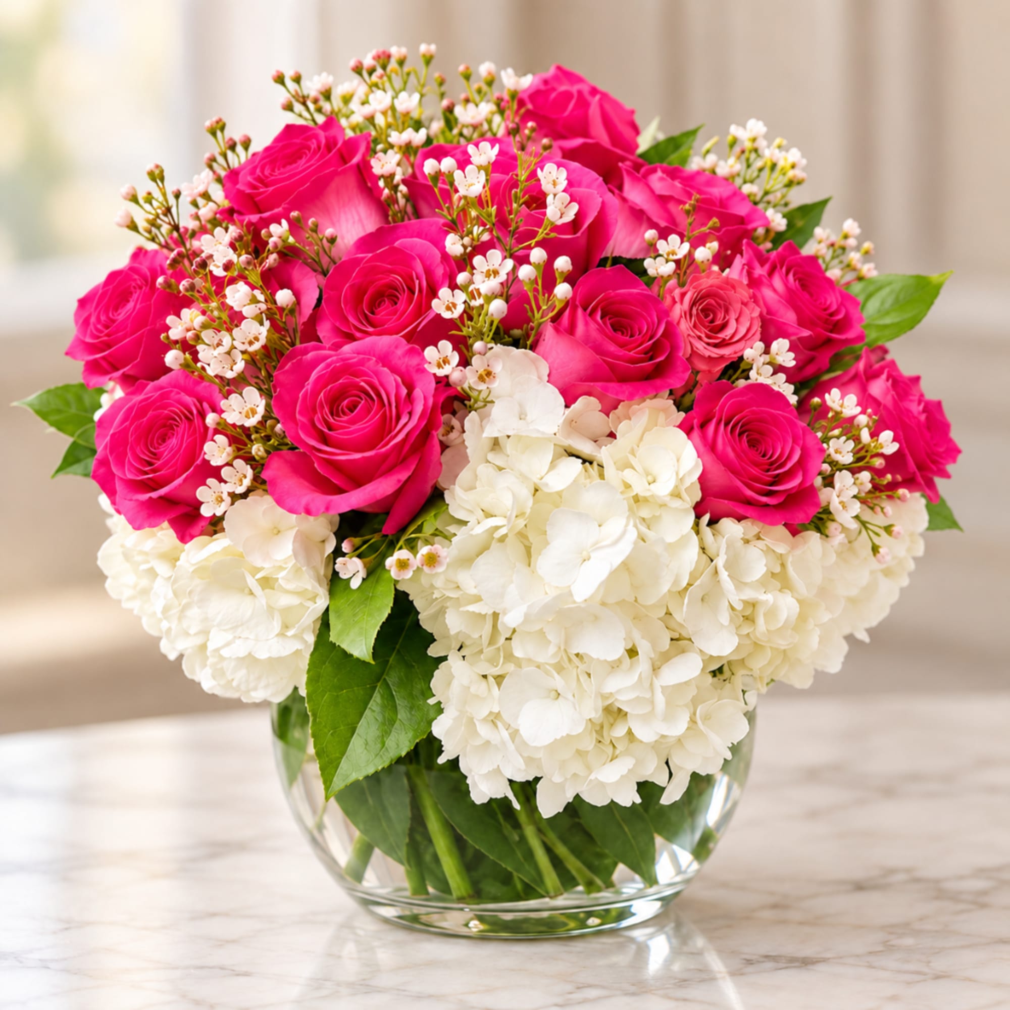 Pink roses and white hydrangeas in a clear glass vase
