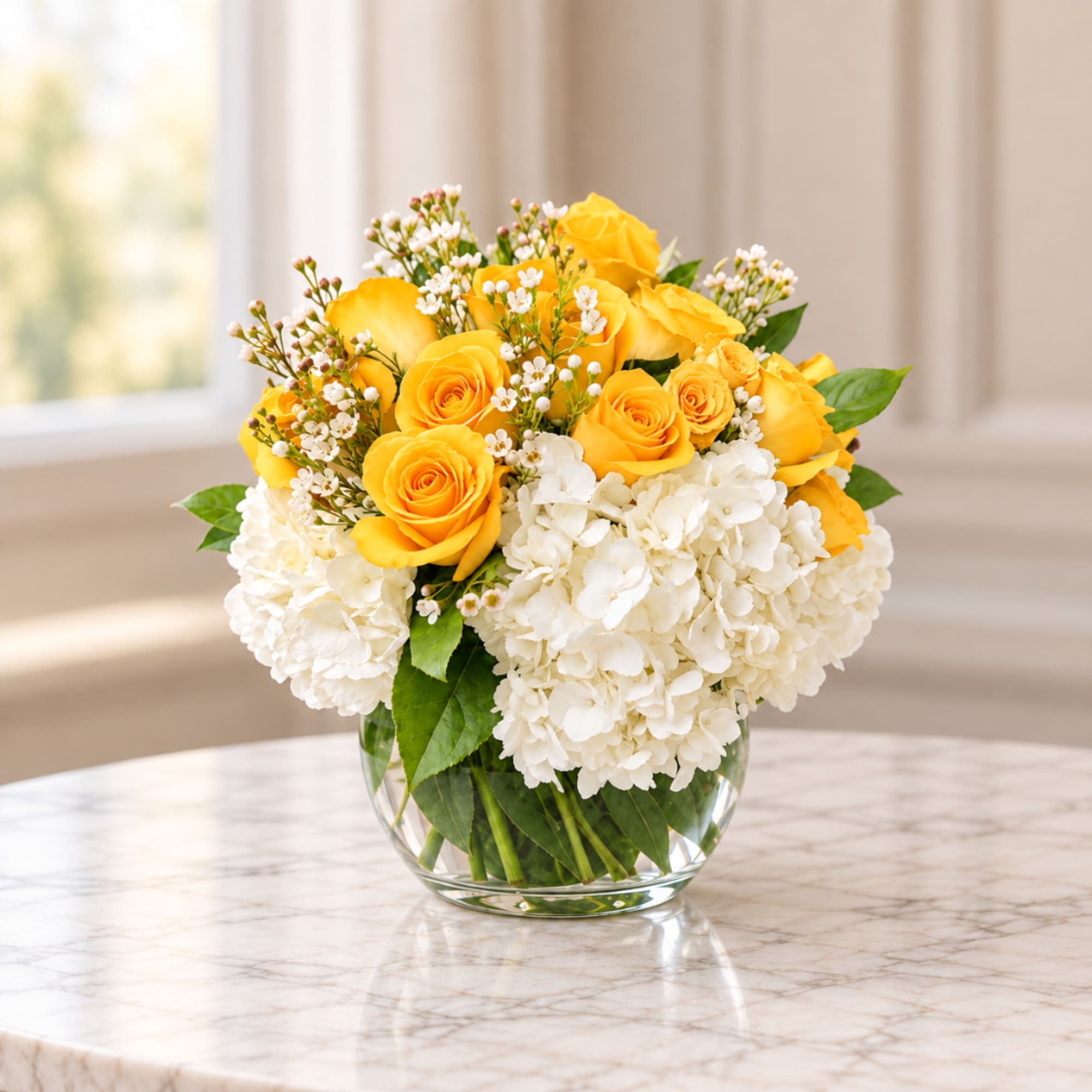 Yellow roses and white hydrangeas in a clear glass vase, photo 2 of 2