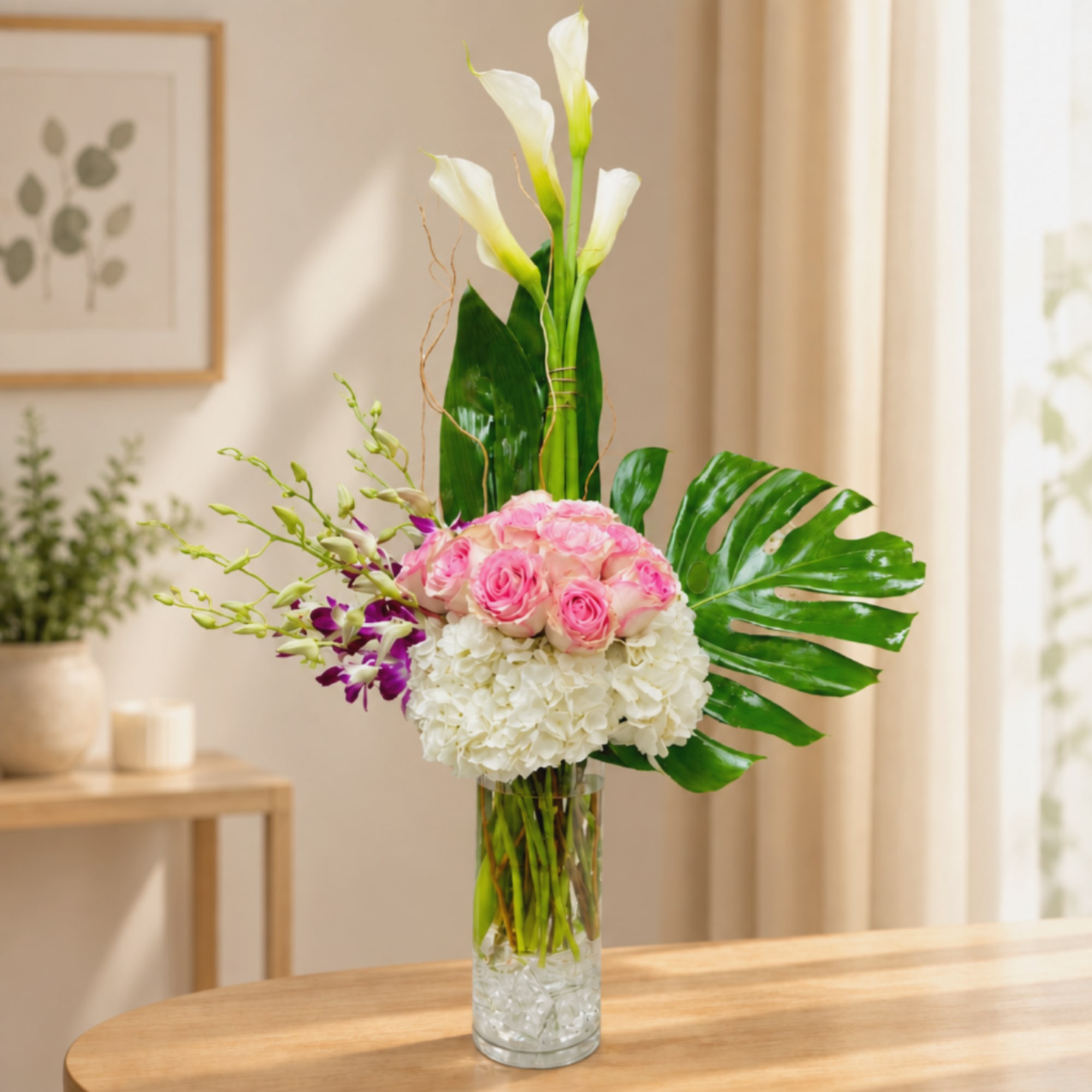 Pink roses and white calla lilies in a clear glass vase