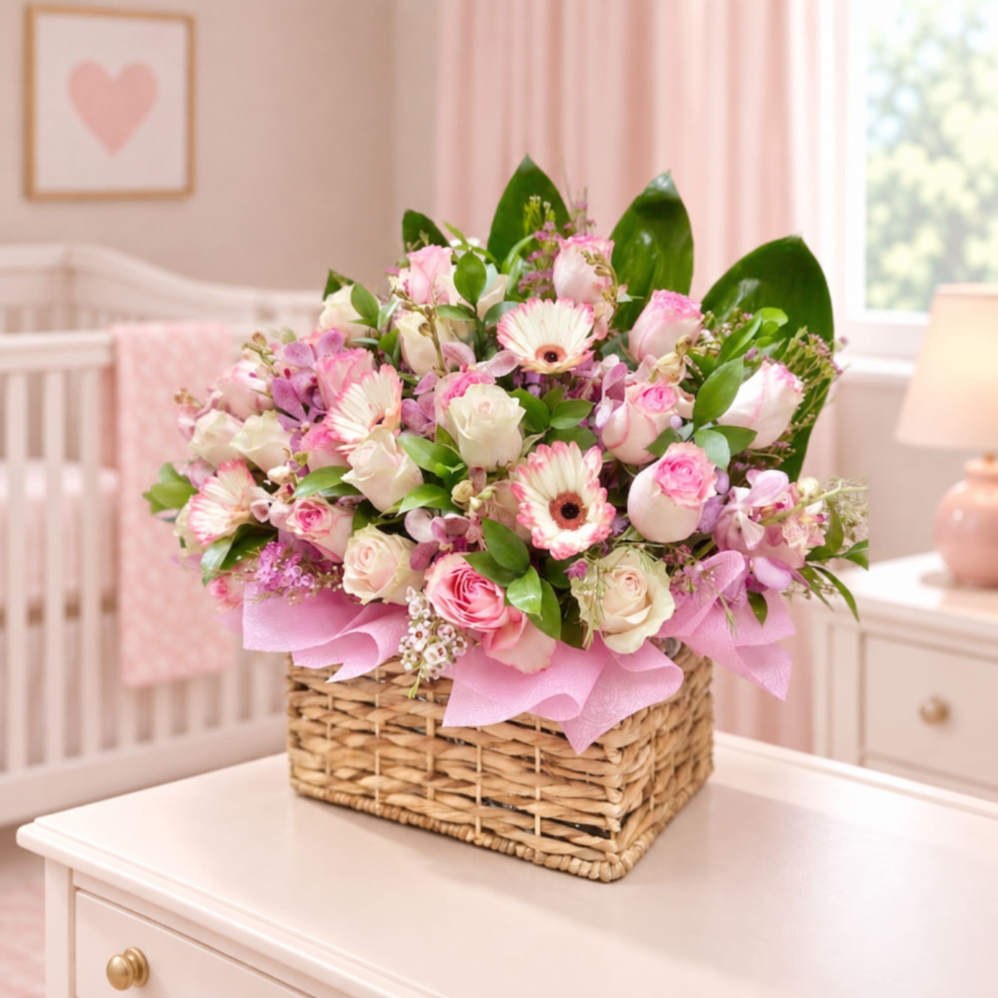 Pink and white flower arrangement in a wicker basket on a table