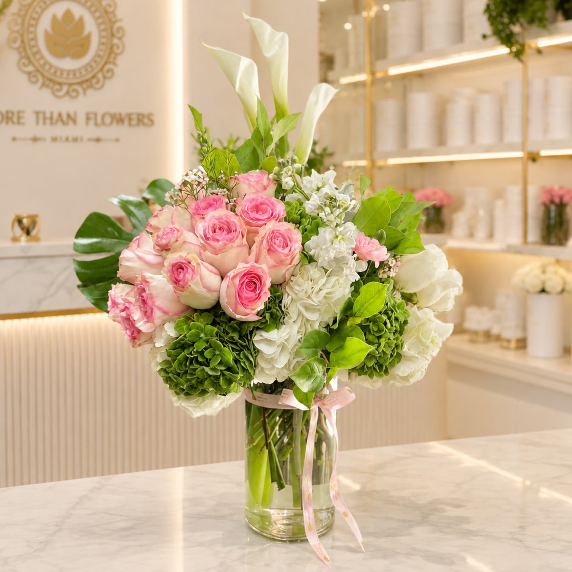 Pink roses and white flowers arranged in a clear glass vase, photo 3 of 5