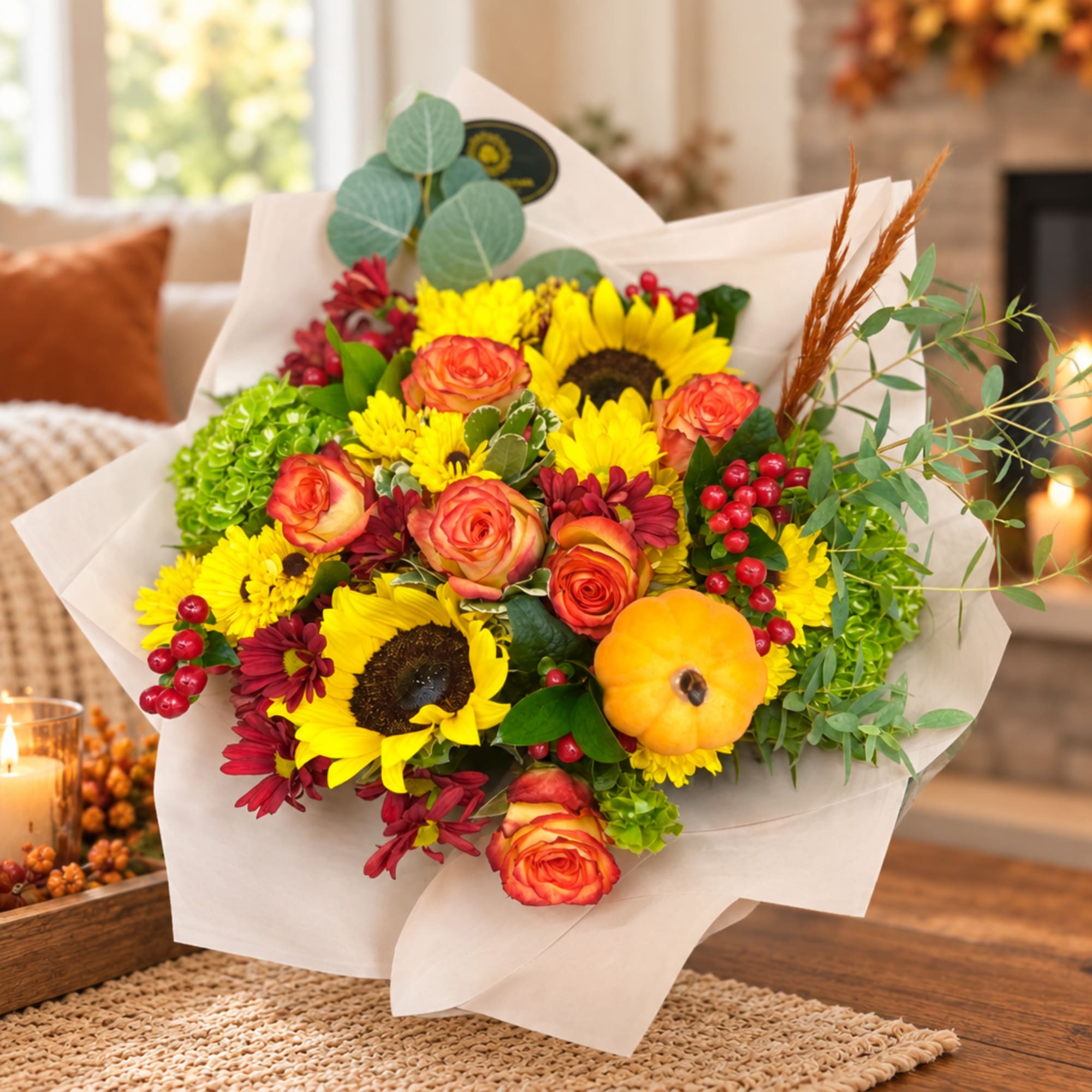 Bouquet of sunflowers, orange roses, and red mums with a small pumpkin