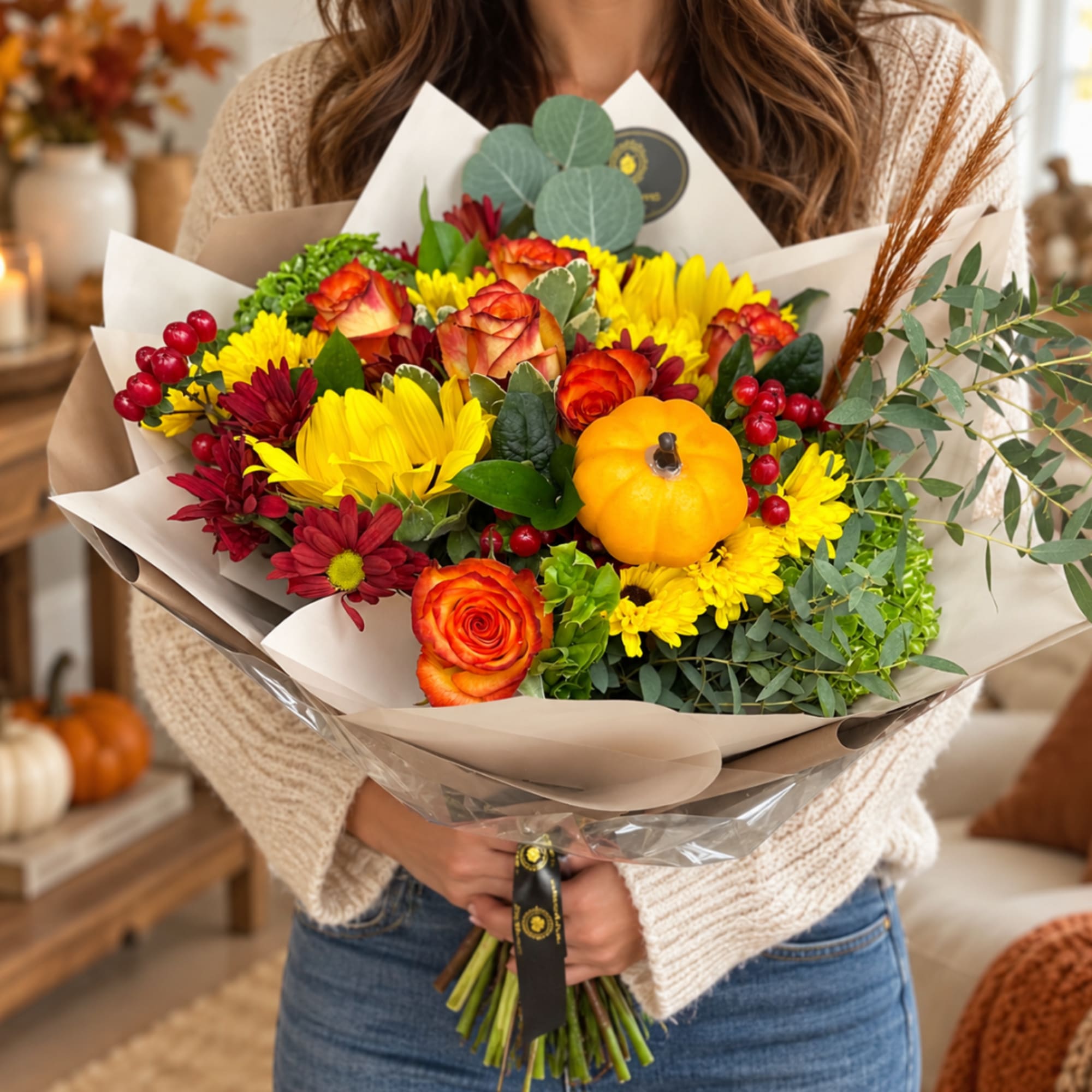 Autumn bouquet with orange roses, yellow mums, and a small pumpkin