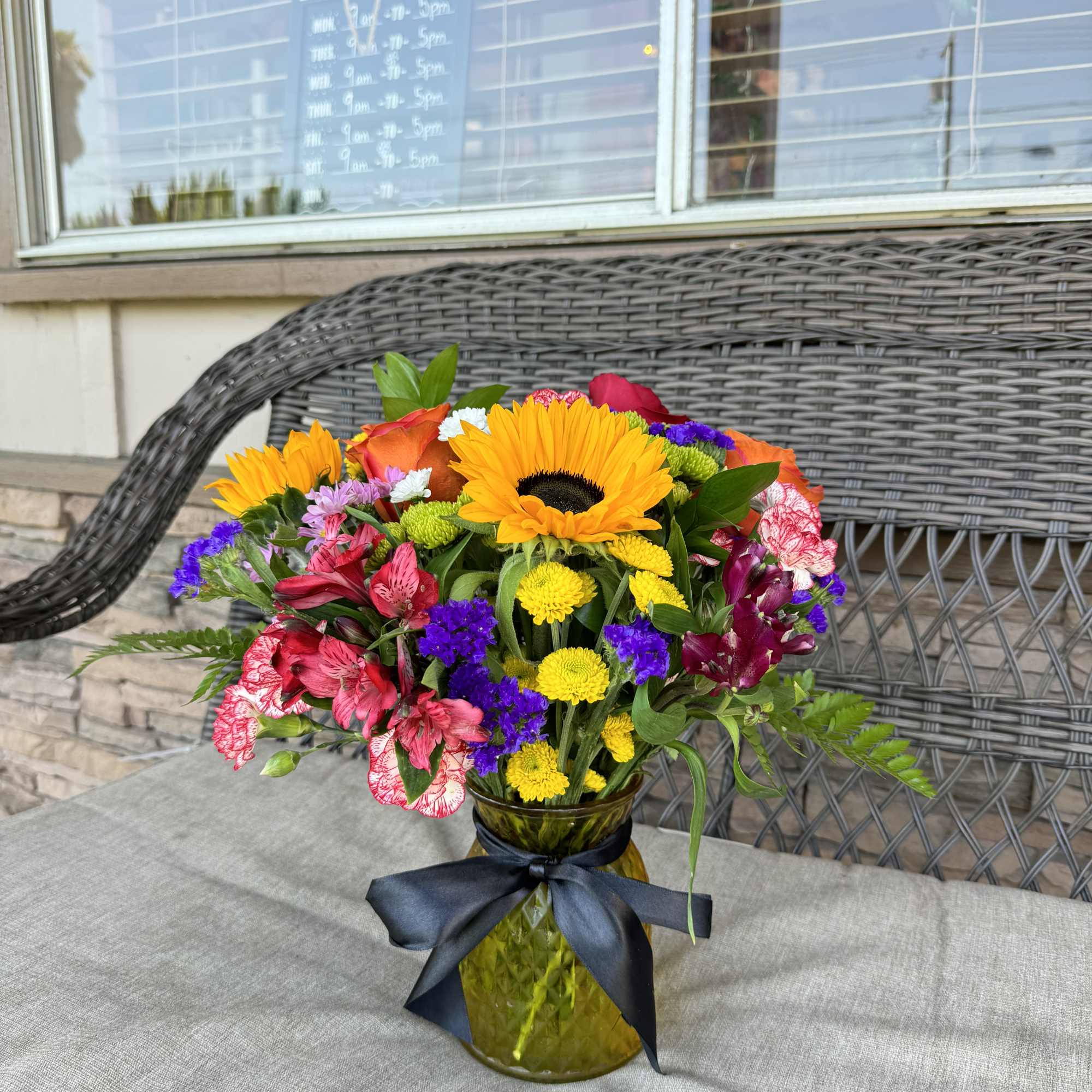 Colorful bouquet in a glass vase with a black ribbon