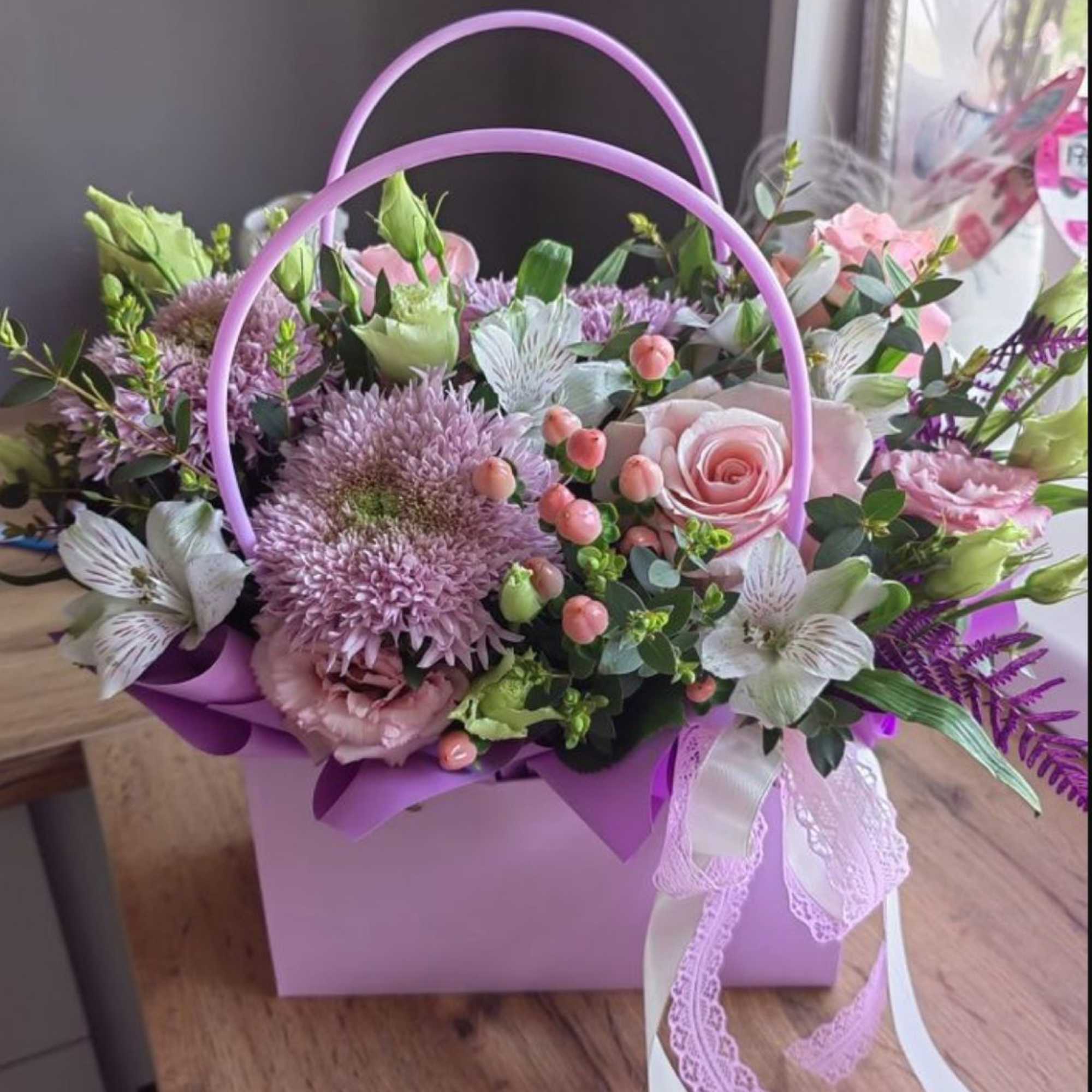 Pink and lavender flower basket with roses and daisies