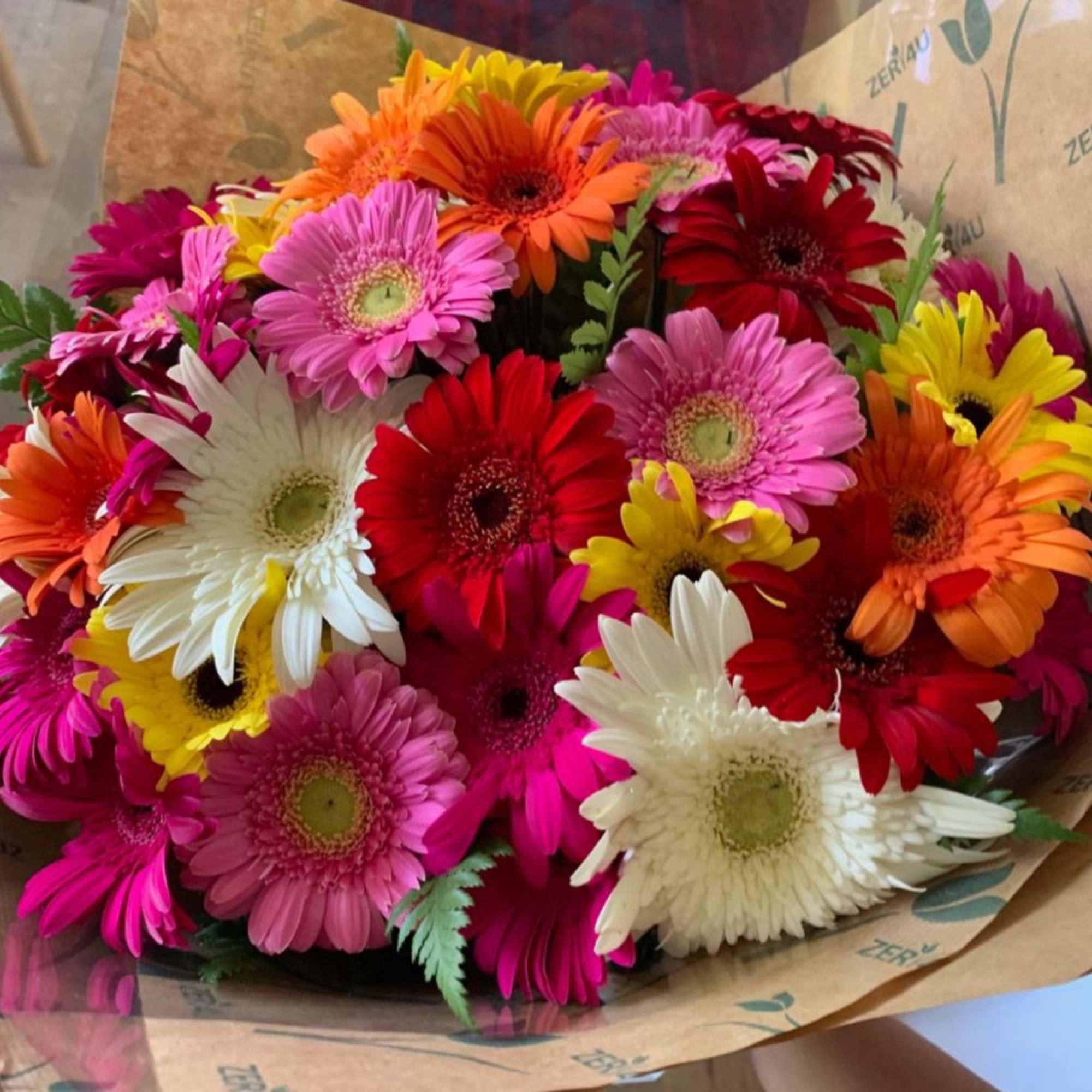 Bouquet of colorful gerbera daisies wrapped in brown paper