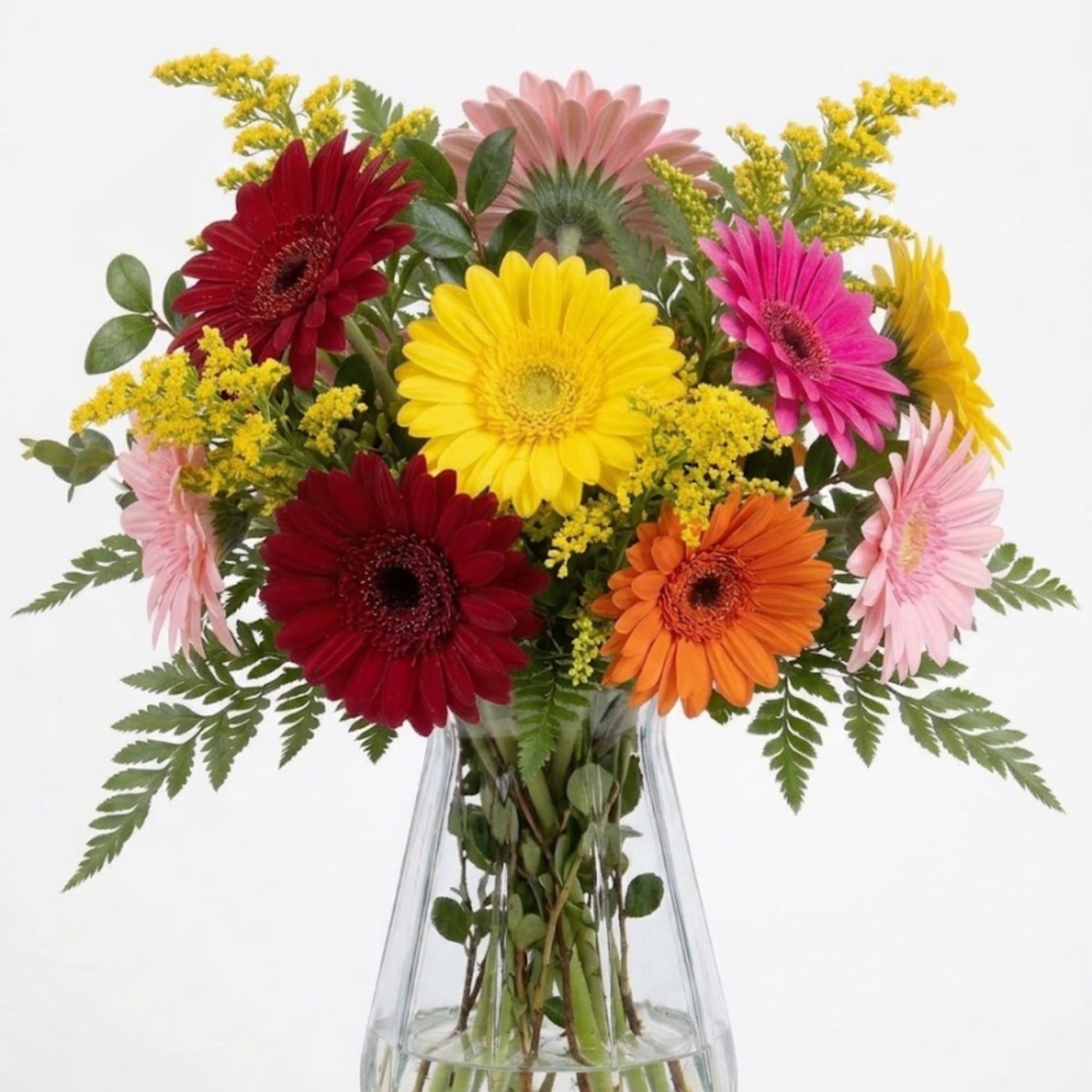Colorful gerbera daisies in a clear glass vase with yellow filler flowers