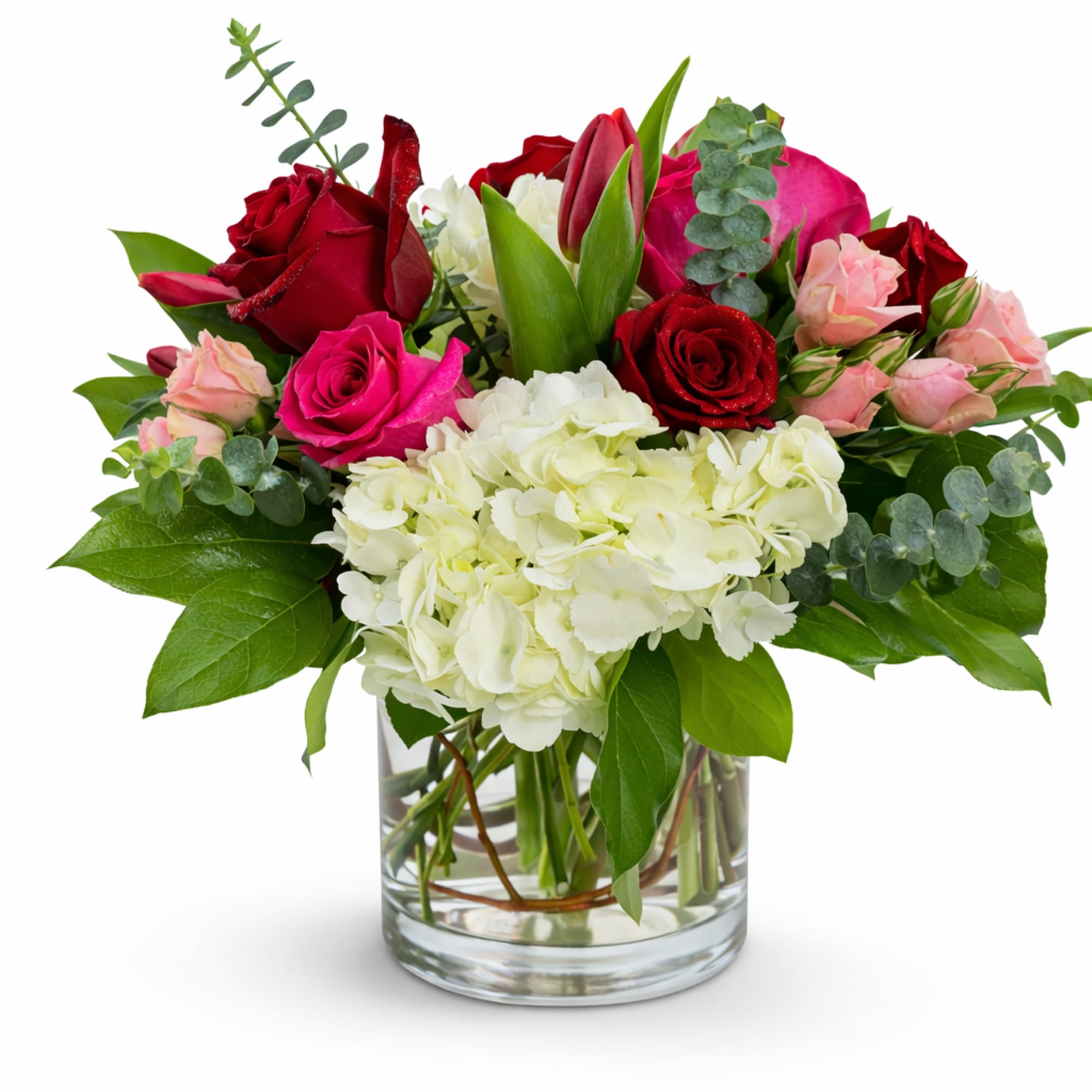 Bouquet of red and pink roses with white hydrangea in a glass vase