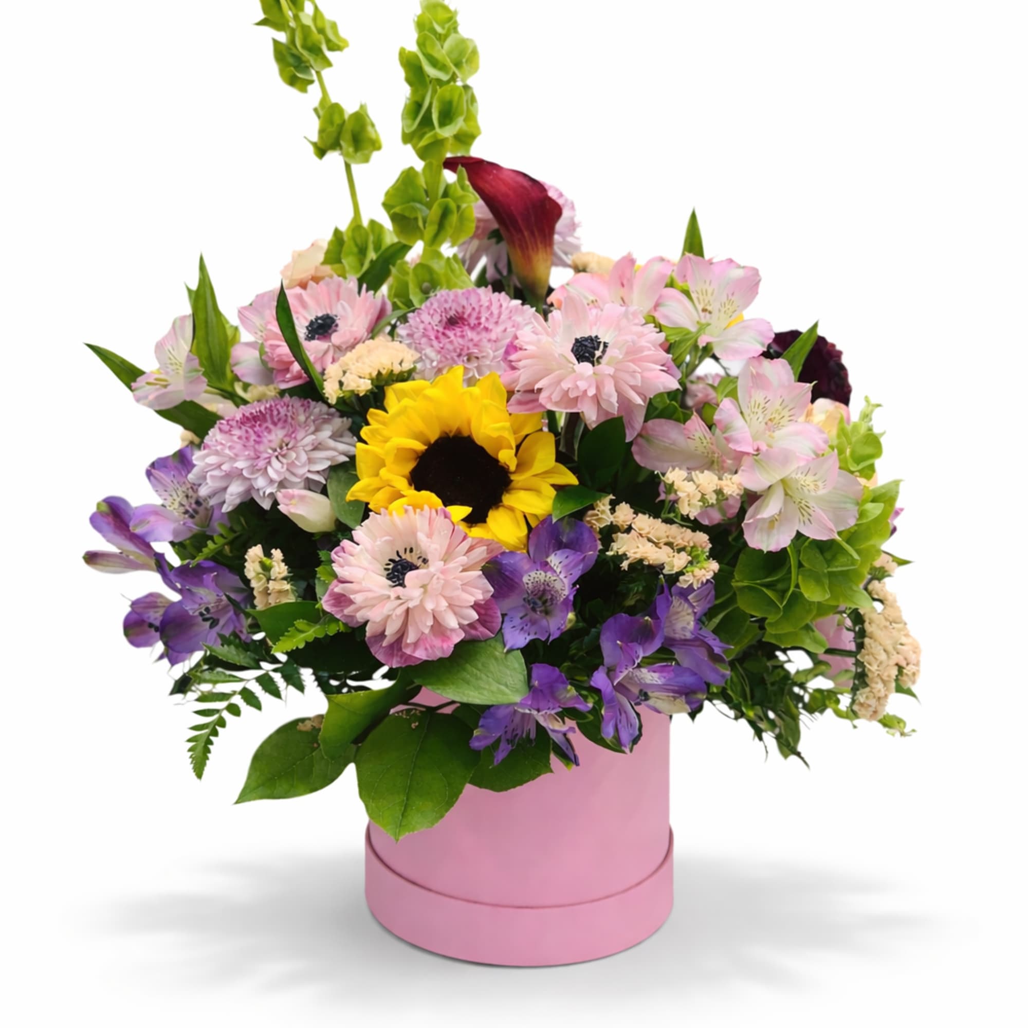 Mixed bouquet in a pink round box with a sunflower and pastel blooms