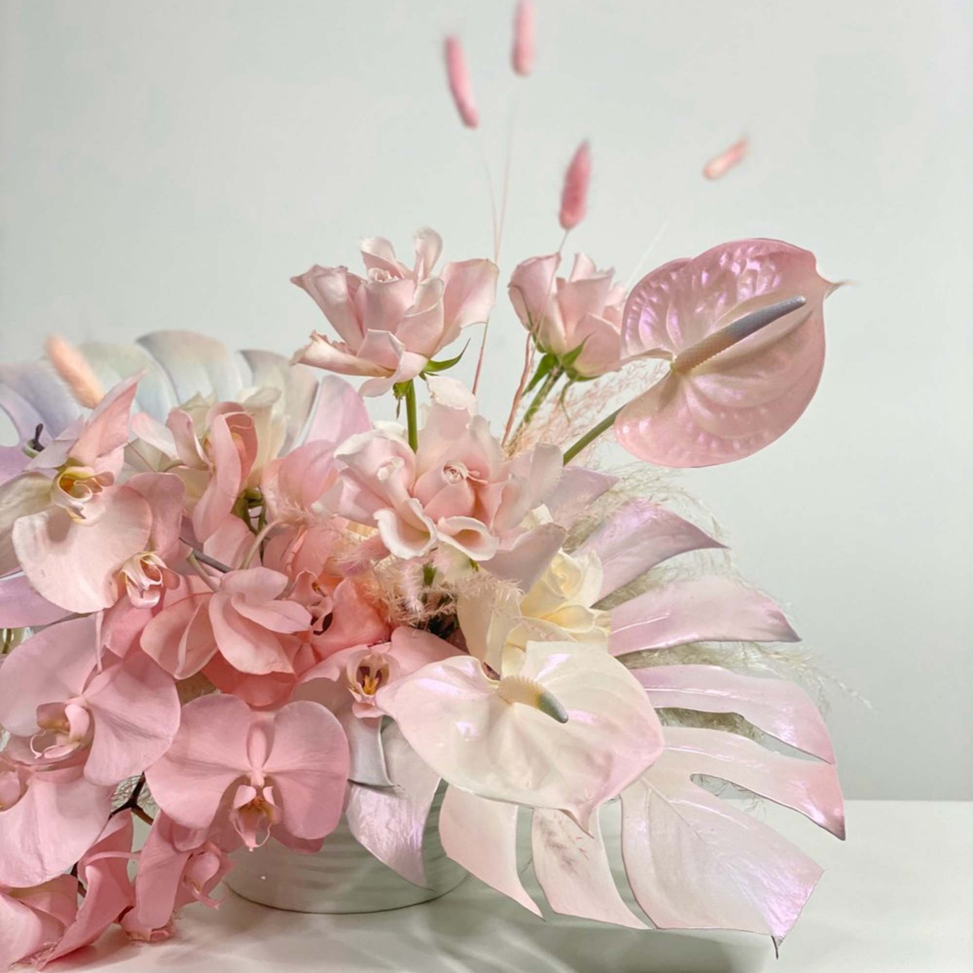 Pink and white orchid arrangement in a low vase