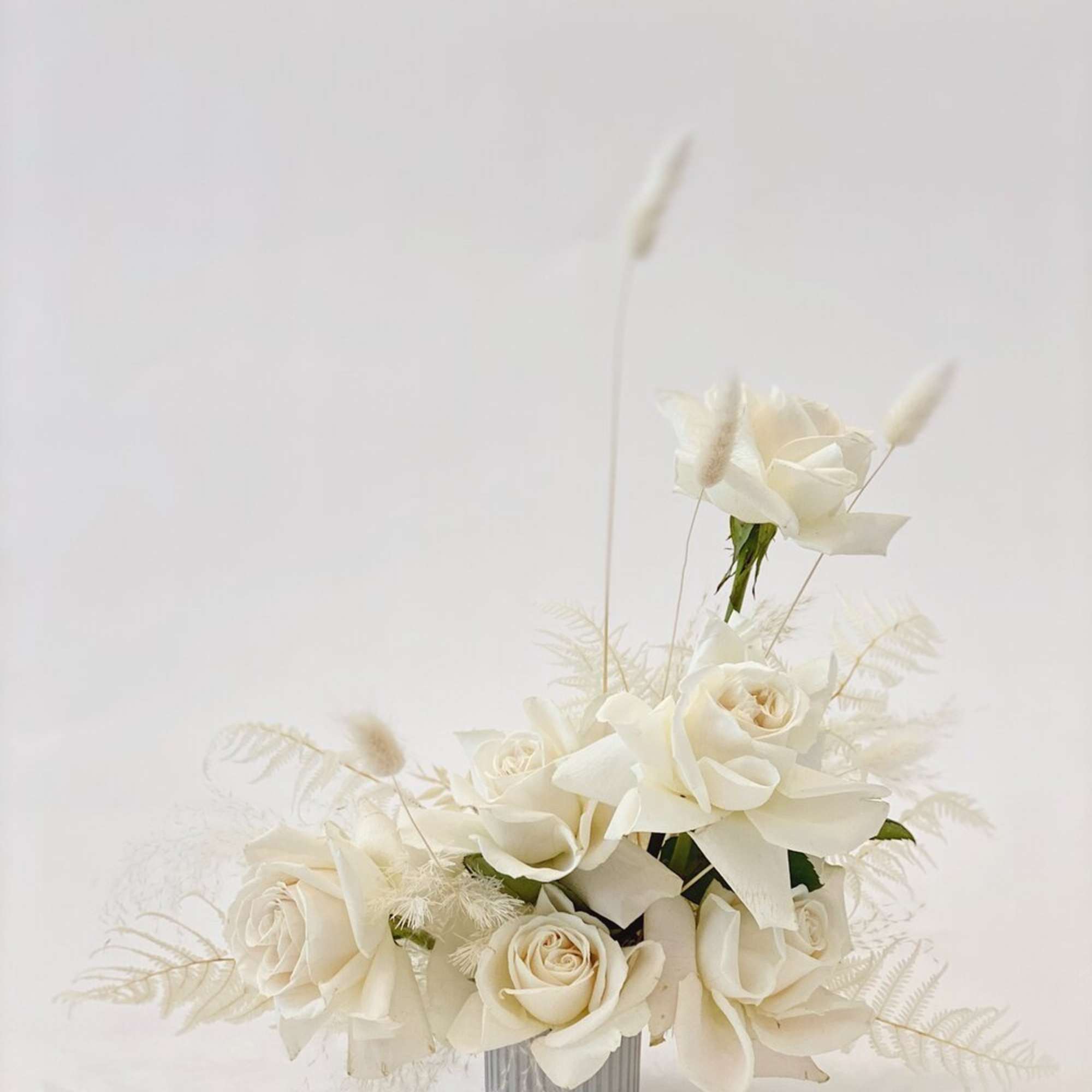 White rose arrangement in a ribbed silver vase