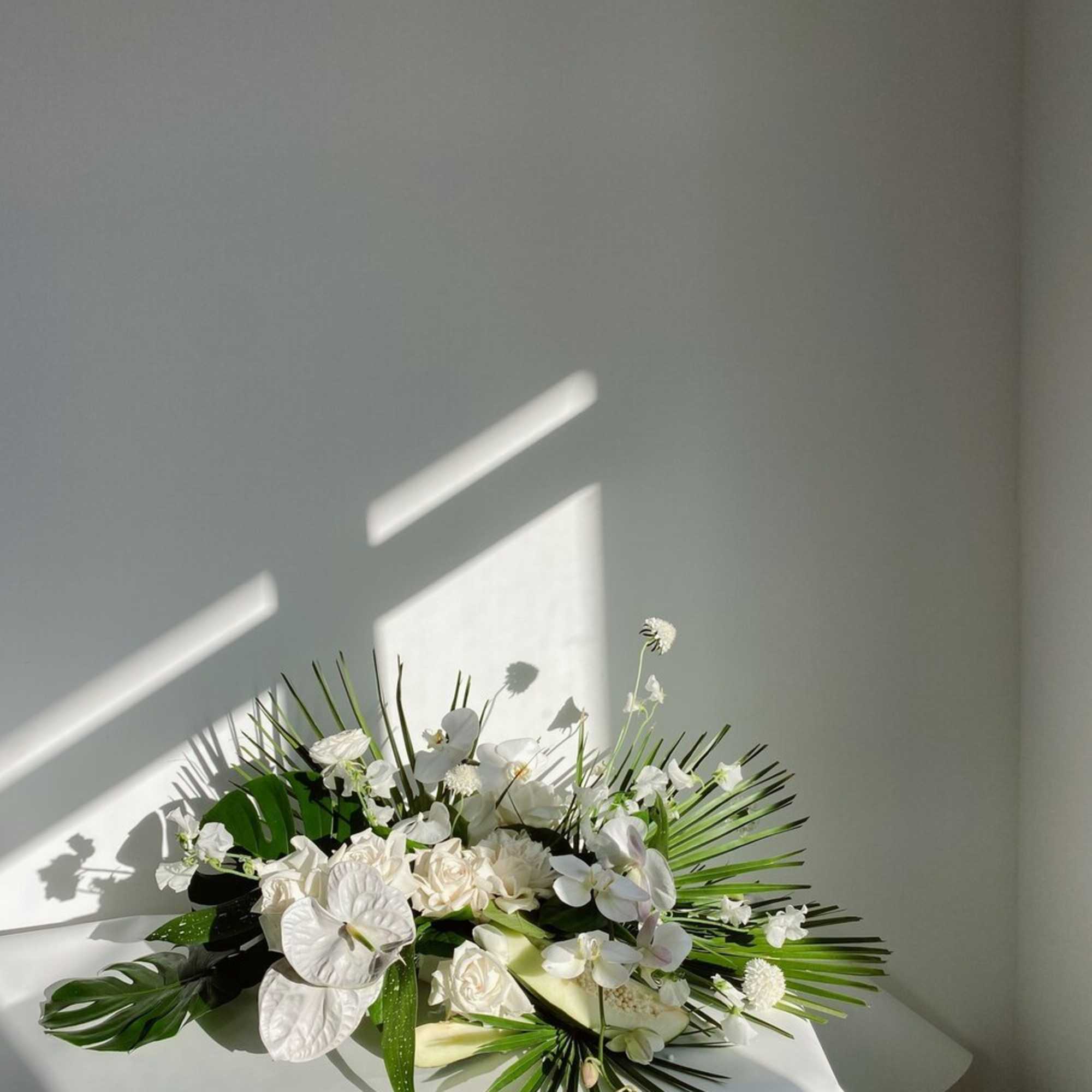 White floral arrangement with orchids and anthuriums on a table