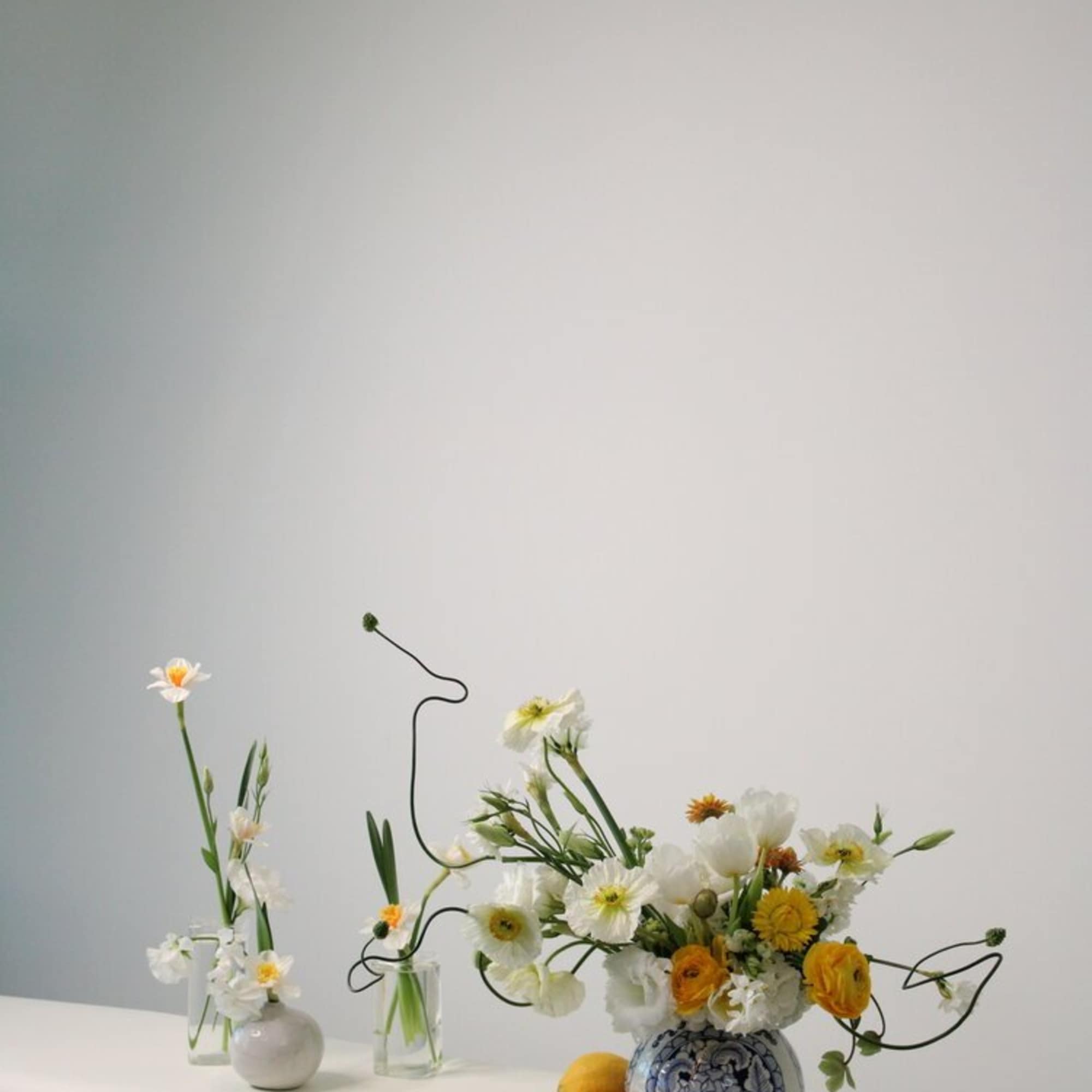 Floral arrangement in a blue-and-white vase with white and yellow blooms