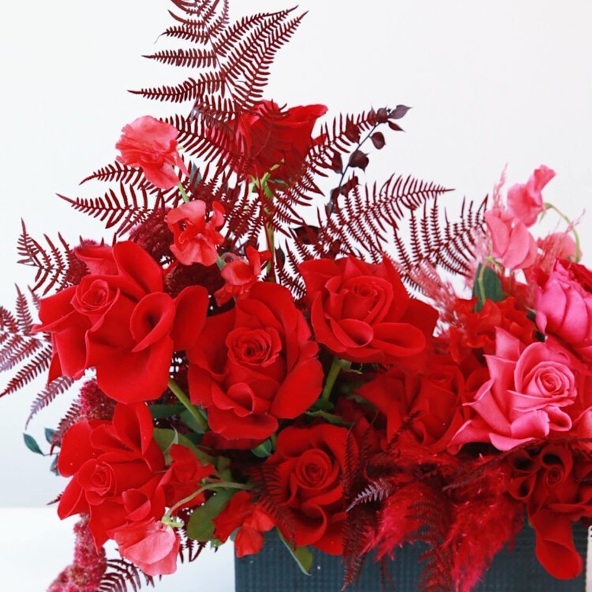 Red and pink roses arranged in a rectangular black container