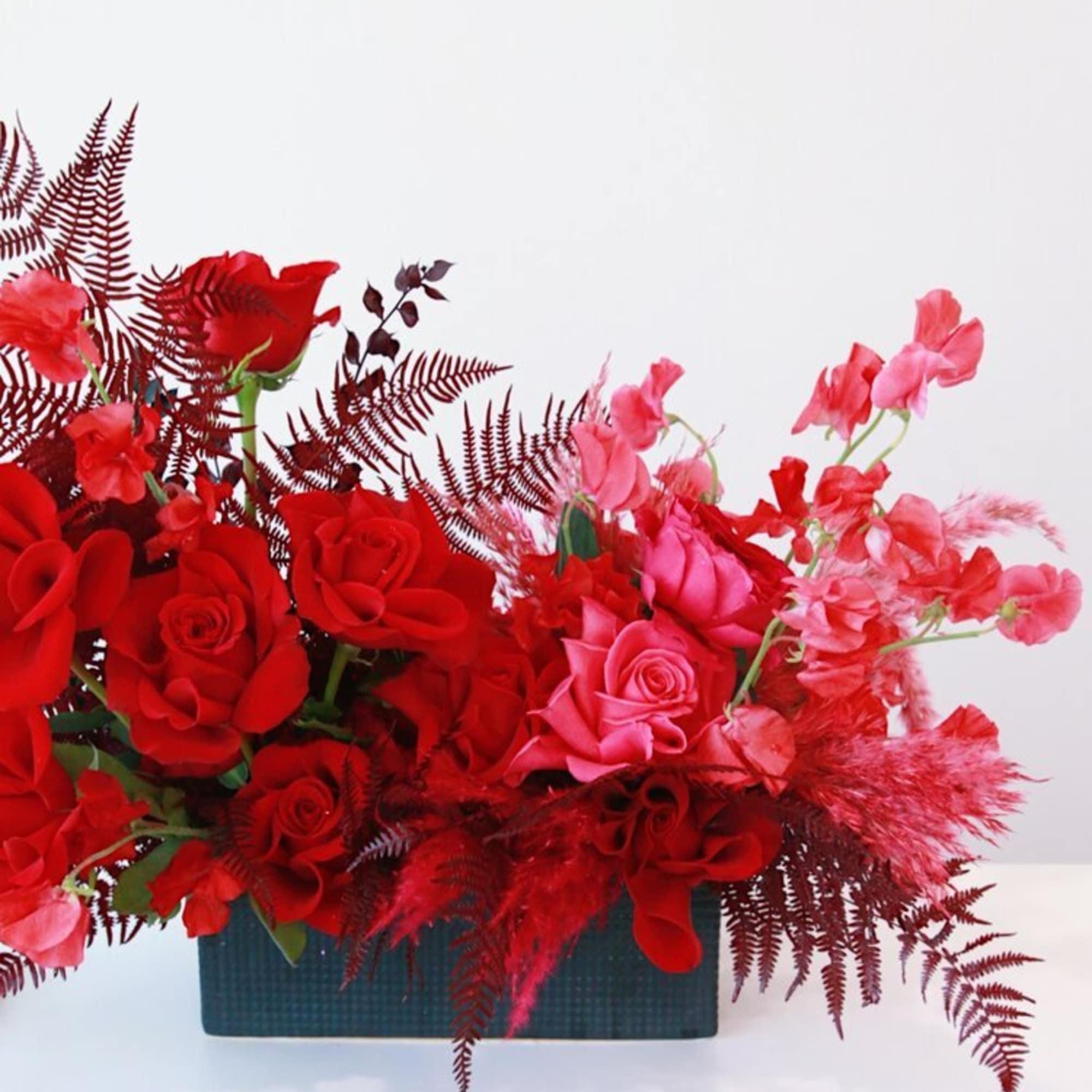 Red and pink roses arranged in a rectangular vase