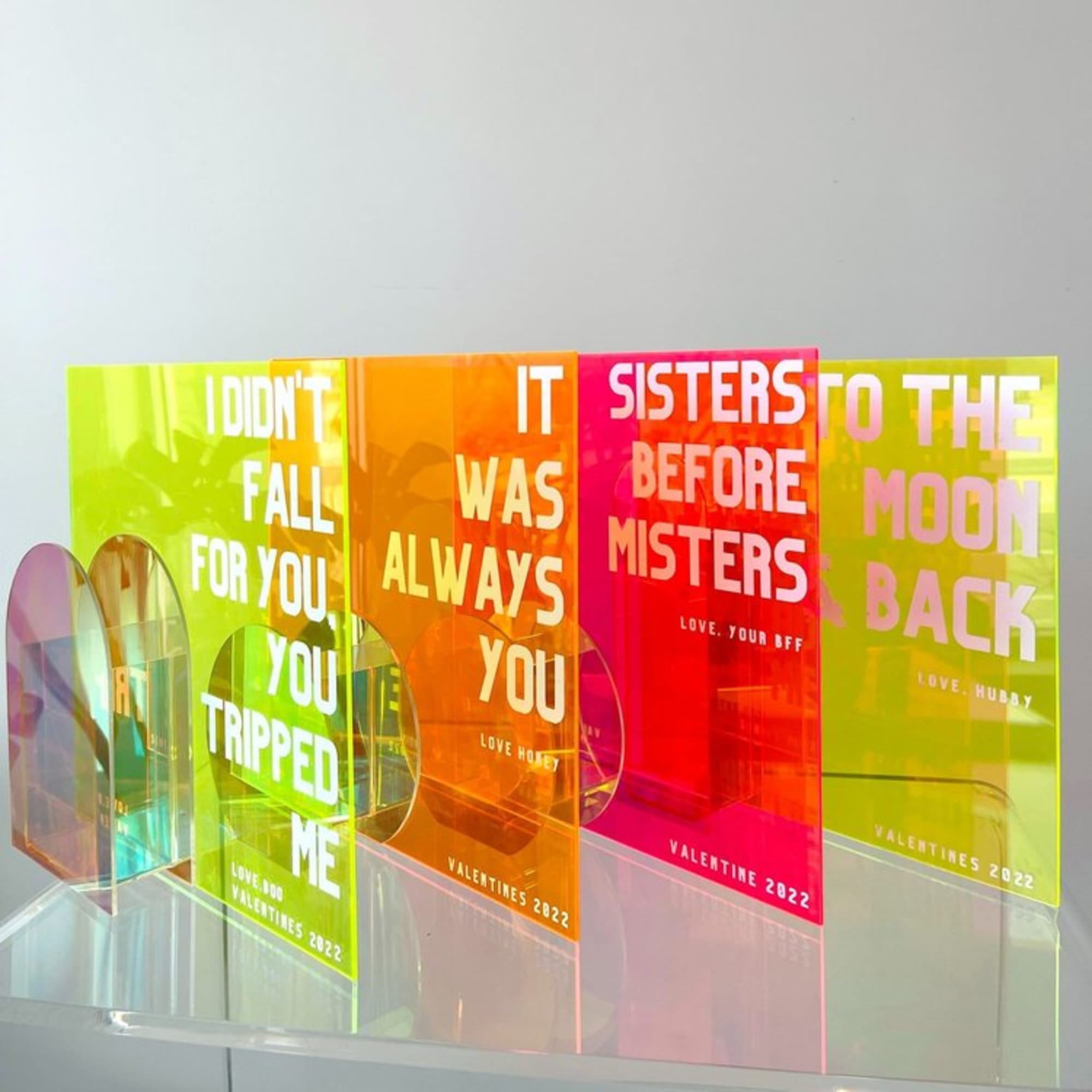 Colorful acrylic Valentine cards with bold text on a shelf