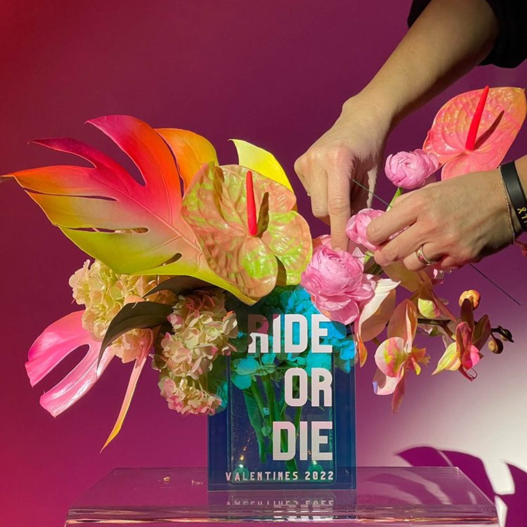 Tropical floral arrangement with pink blooms in a clear vase