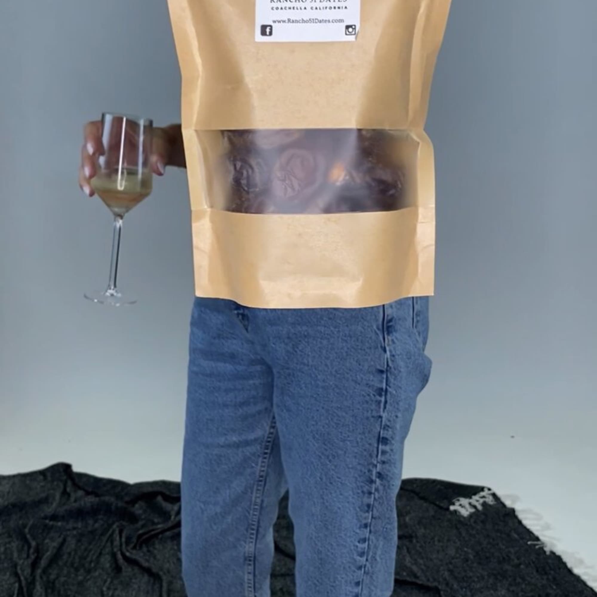 Person holding a date pouch and a wine glass