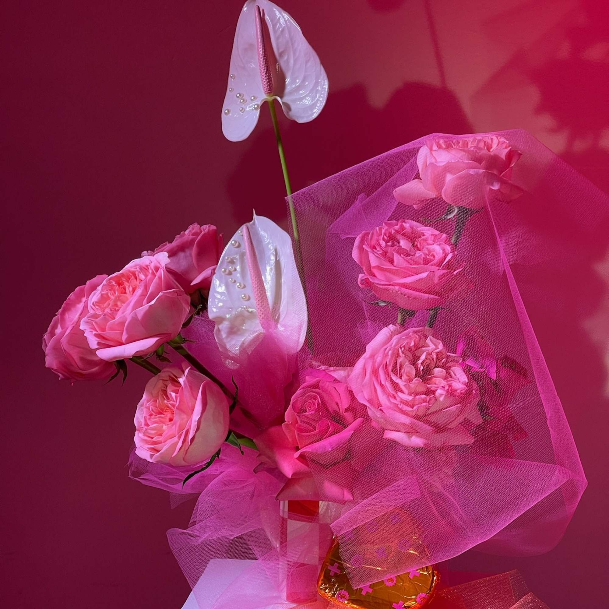 Pink roses with white anthuriums wrapped in pink tulle