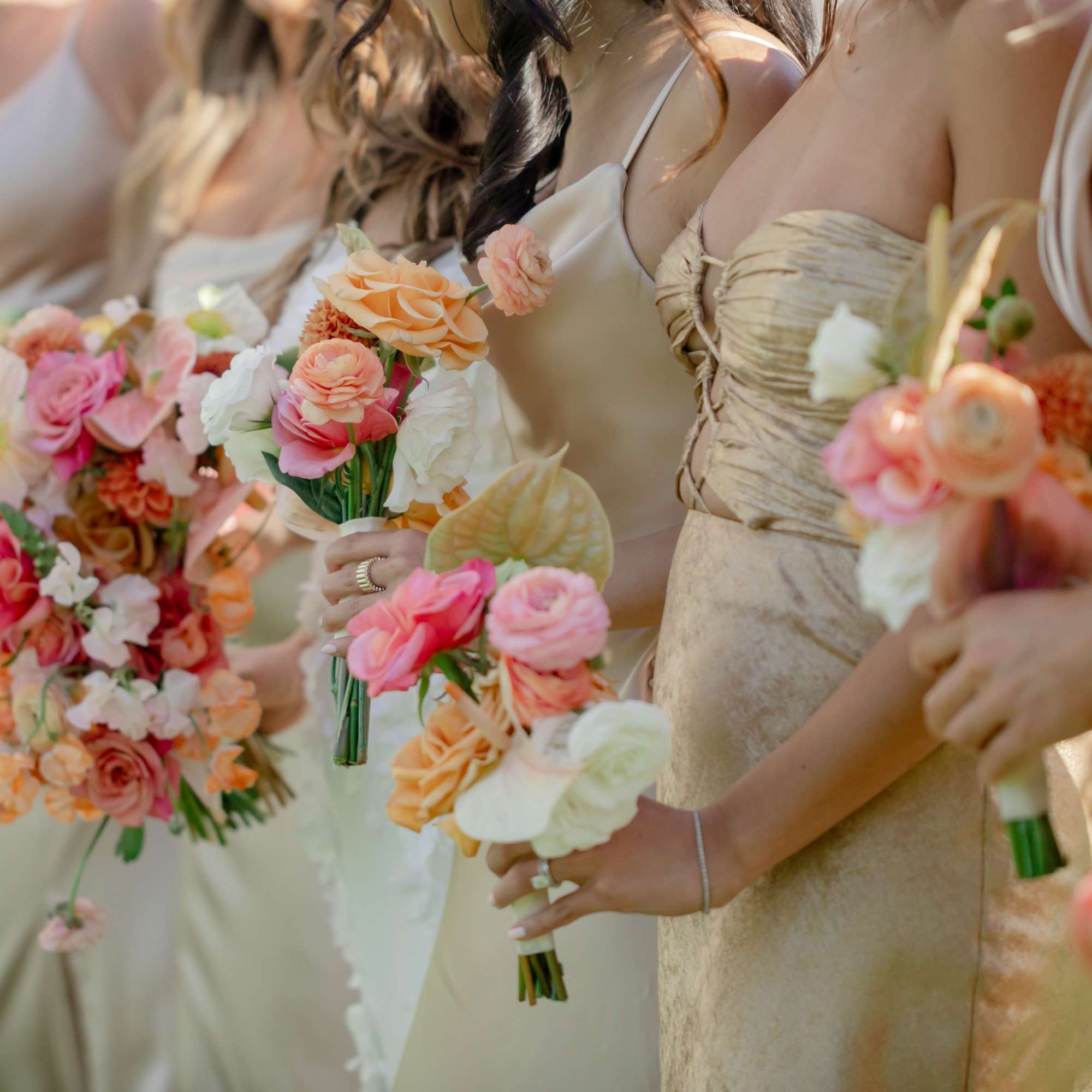 Bridesmaids holding pastel bouquets with roses and white flowers