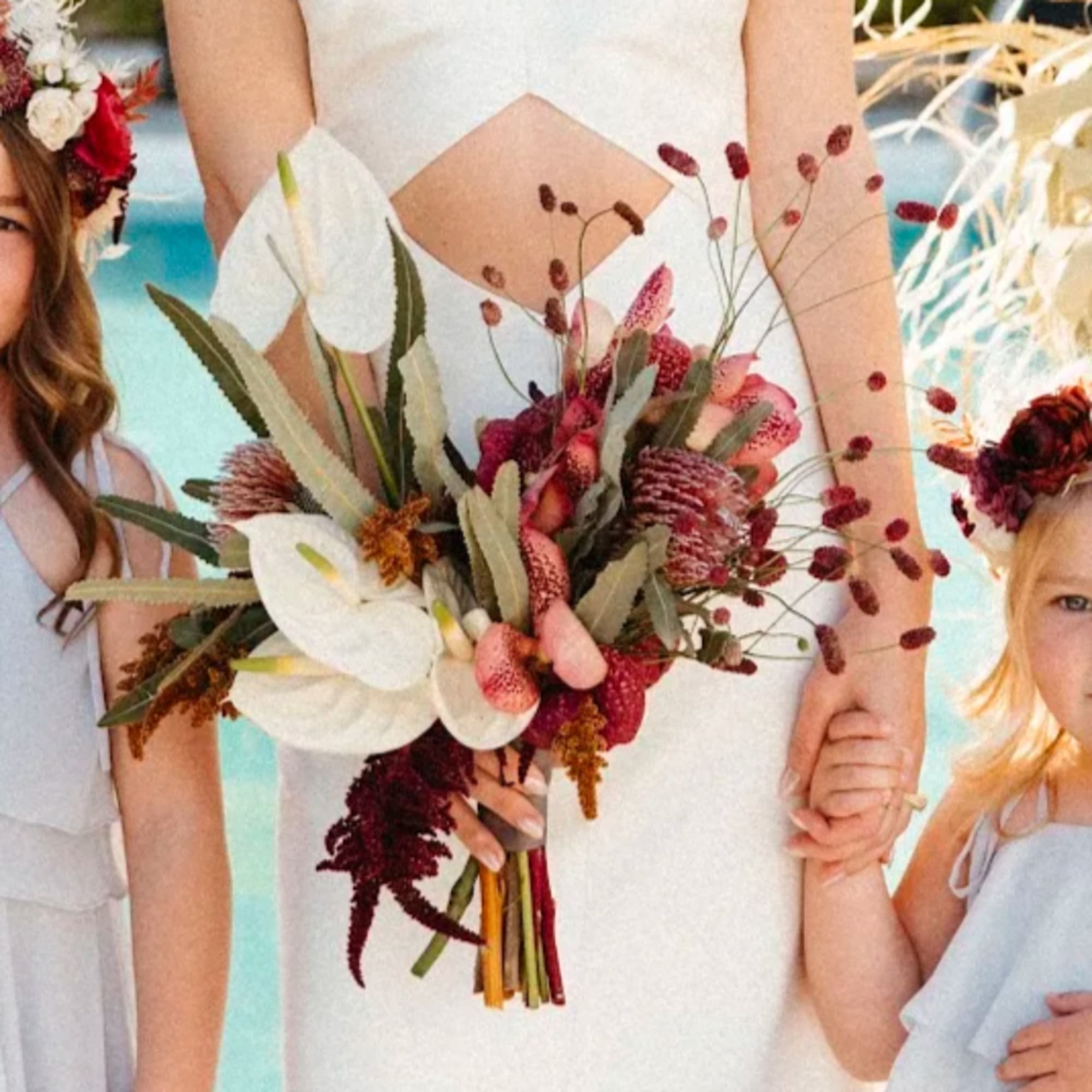 Bride holding a bouquet of white calla lilies and burgundy flowers