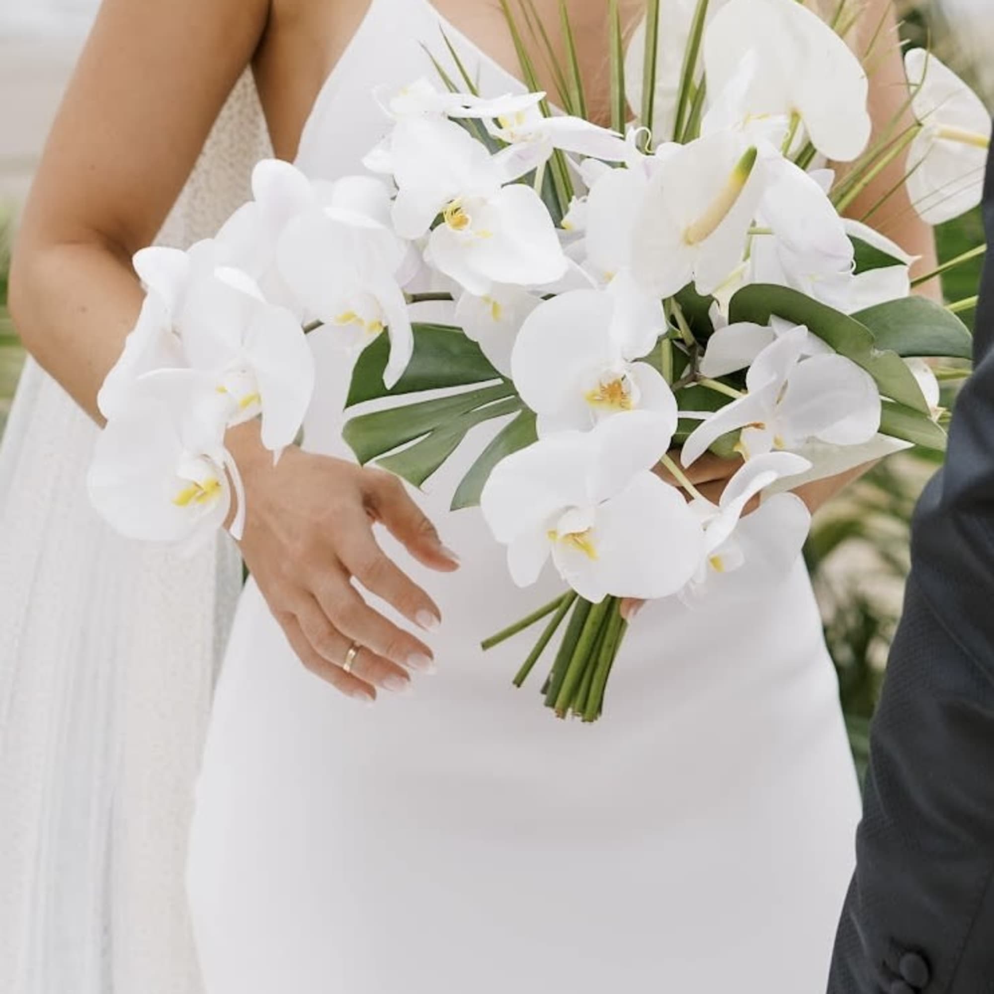 Bride holding a white orchid bouquet